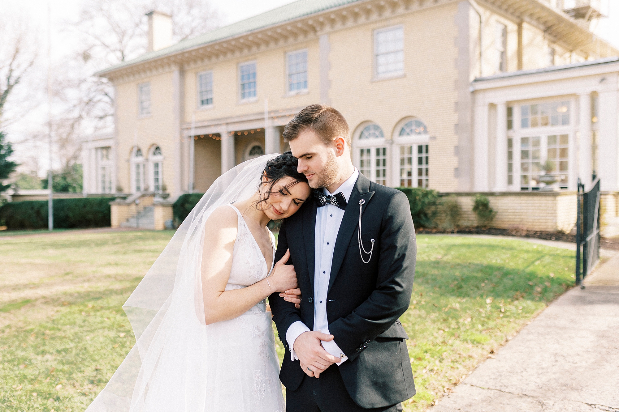 bride leans head on groom's shoulder during portraits in gardens at Separk Mansion
