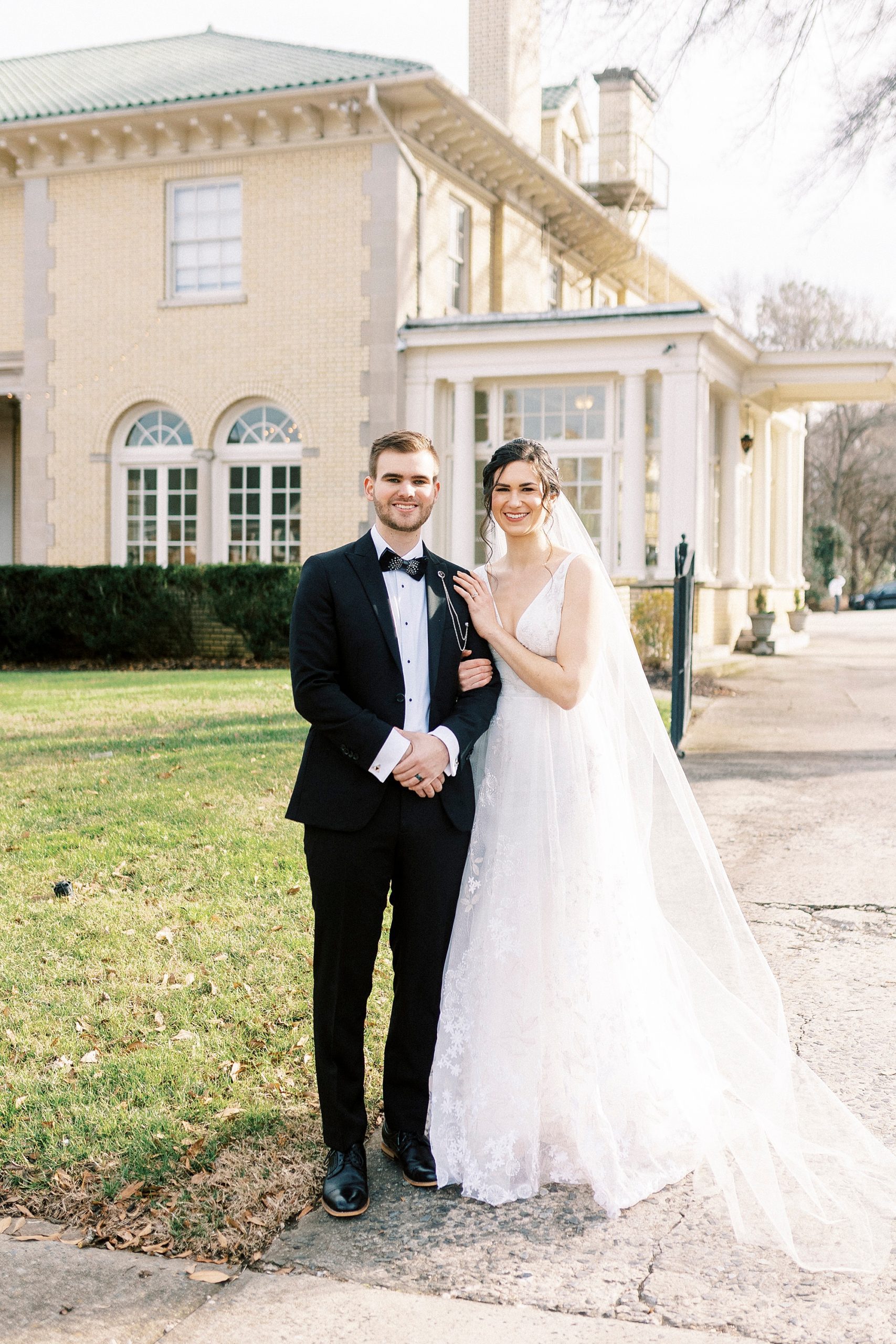 bride and groom stand on sidewalk outside Separk Mansion