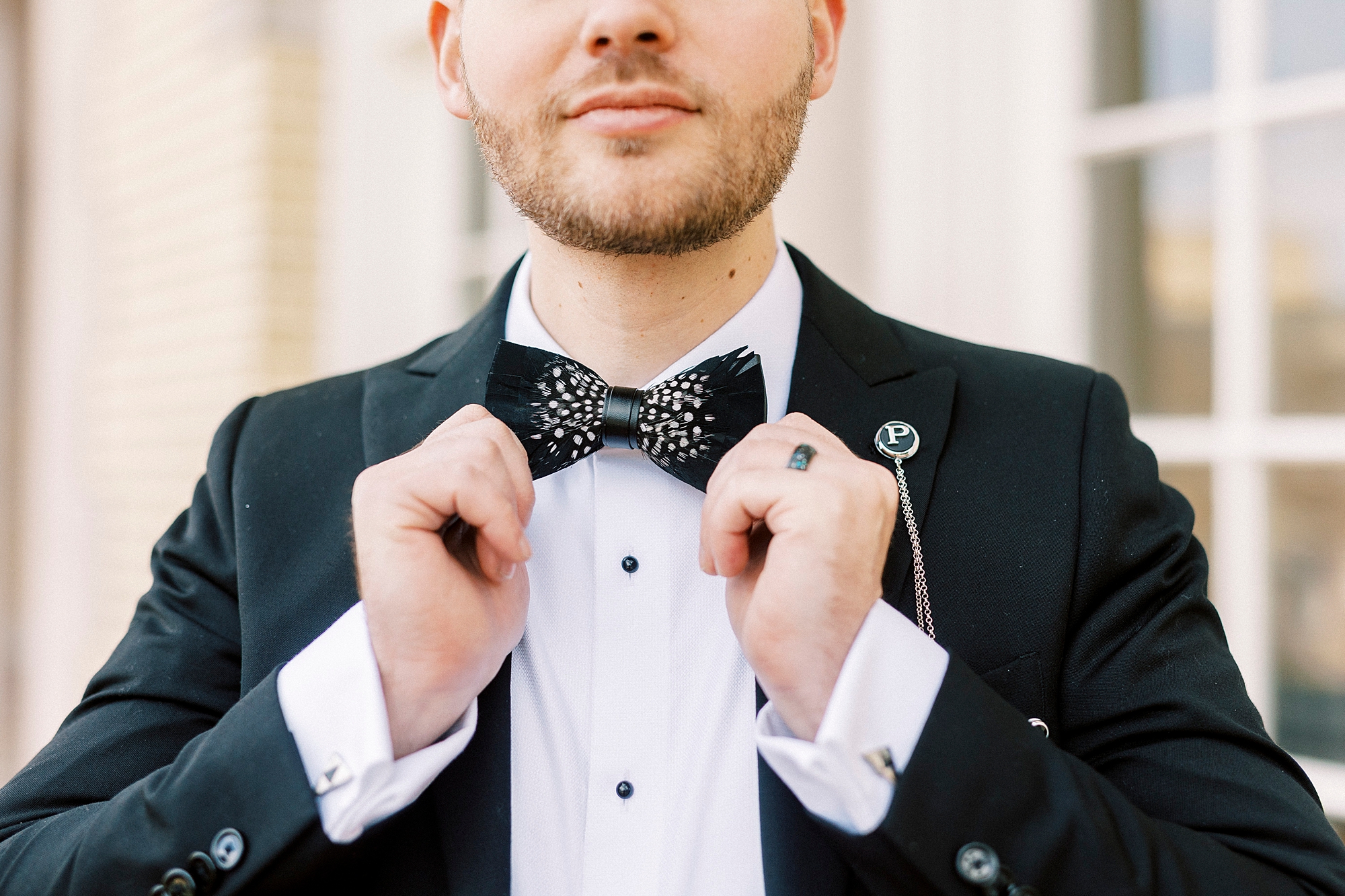 groom adjusts custom tie for winter wedding 