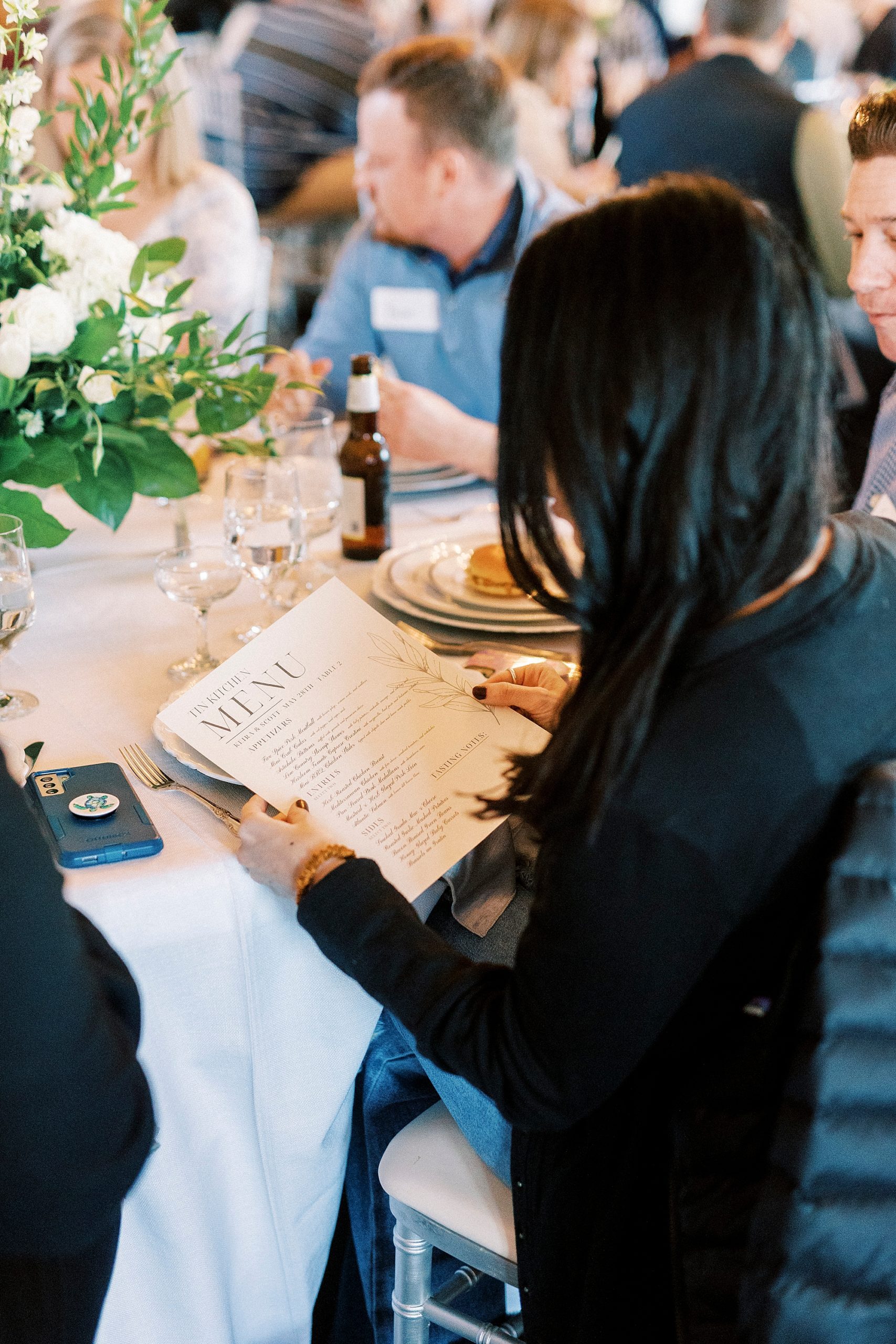 woman reads menu during Grand Tasting Event at Separk Mansion in winter 2023 
