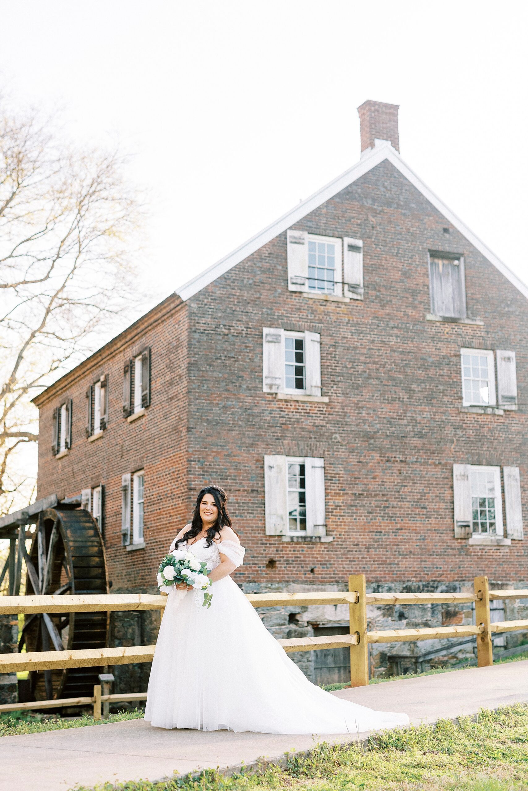 bride stands by brick house in Sloan Park