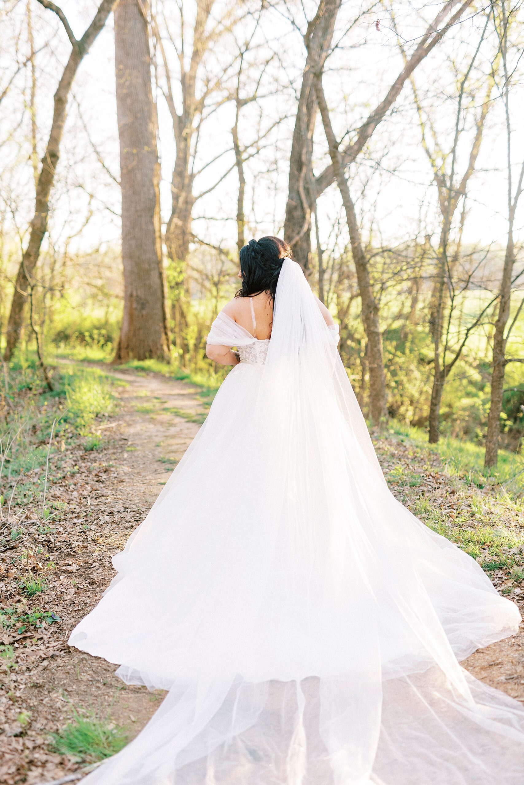 bride walks away fro camera with veil trailing behind her