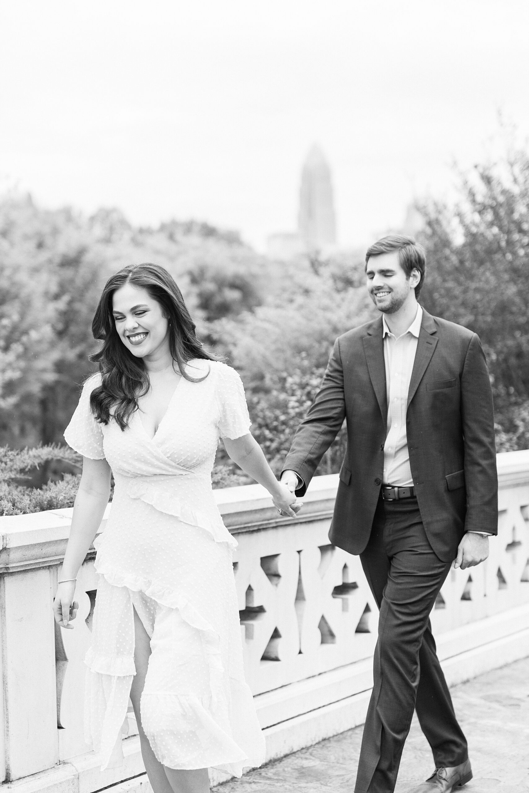 woman holds hand leading man down bridge at Midtown Park