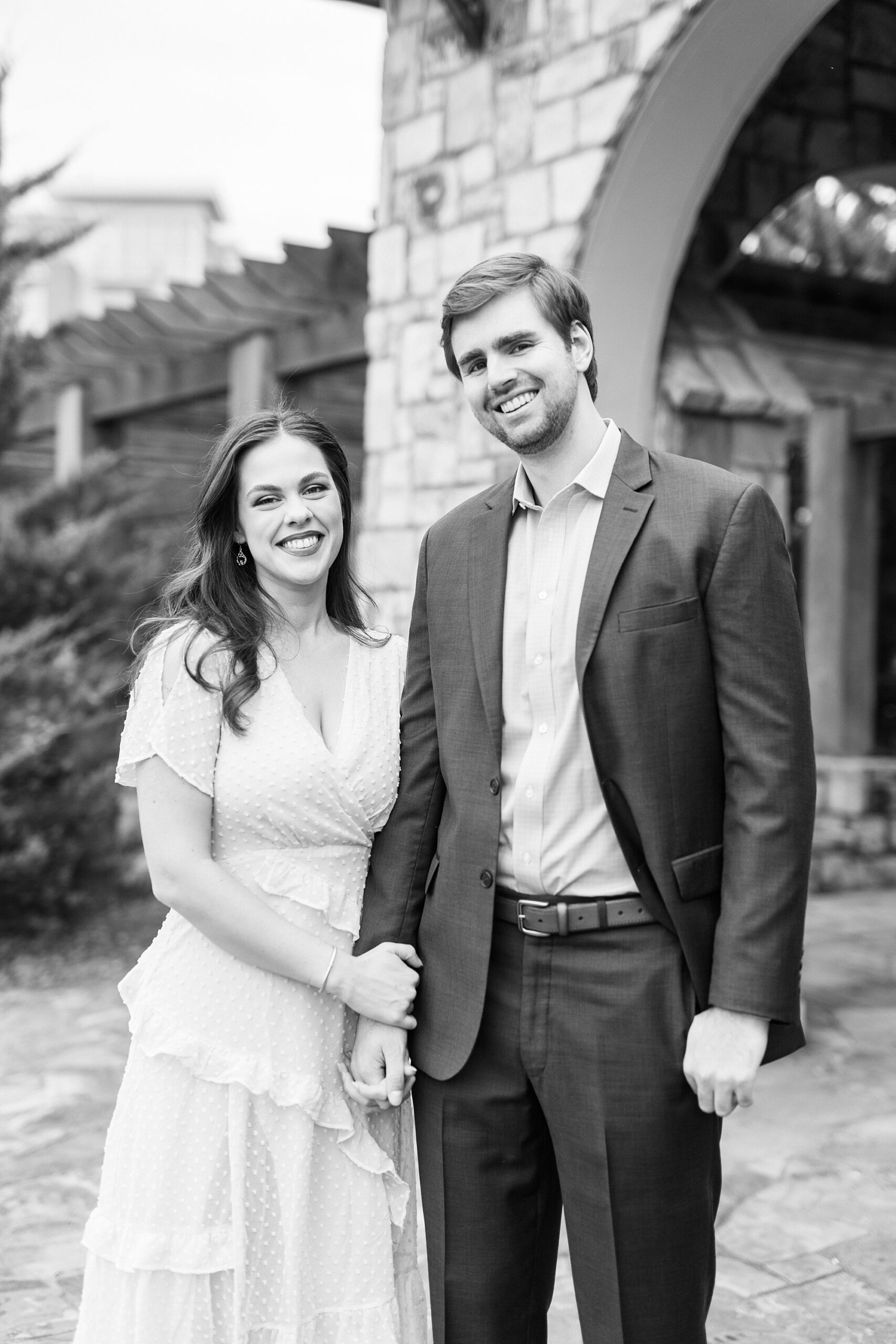 engaged couple holds hands smiling at photographer 