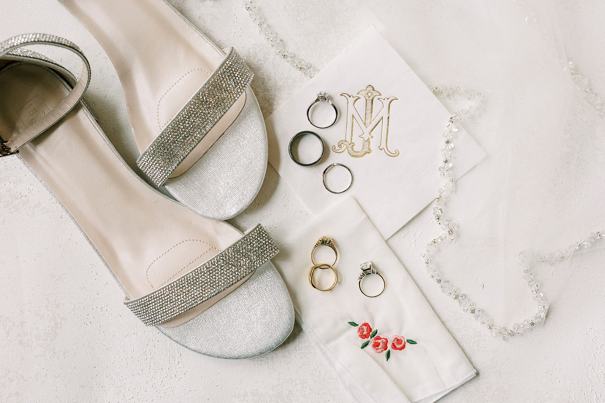 bride's silver shoes and wedding bands on handkerchief 