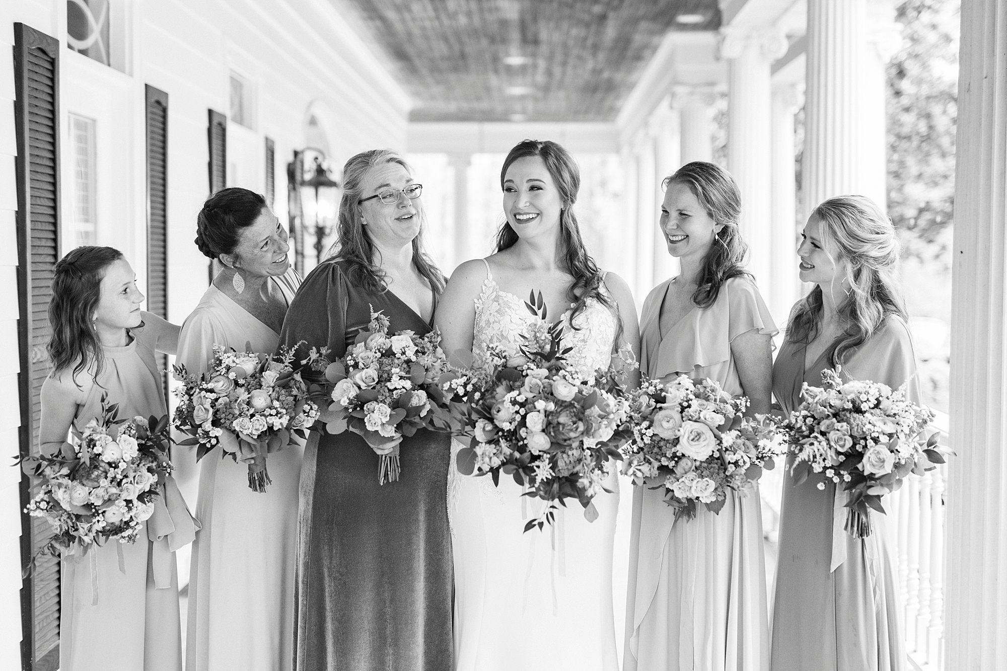 bride smiles with bridesmaids on the porch at The Saratoga Springs