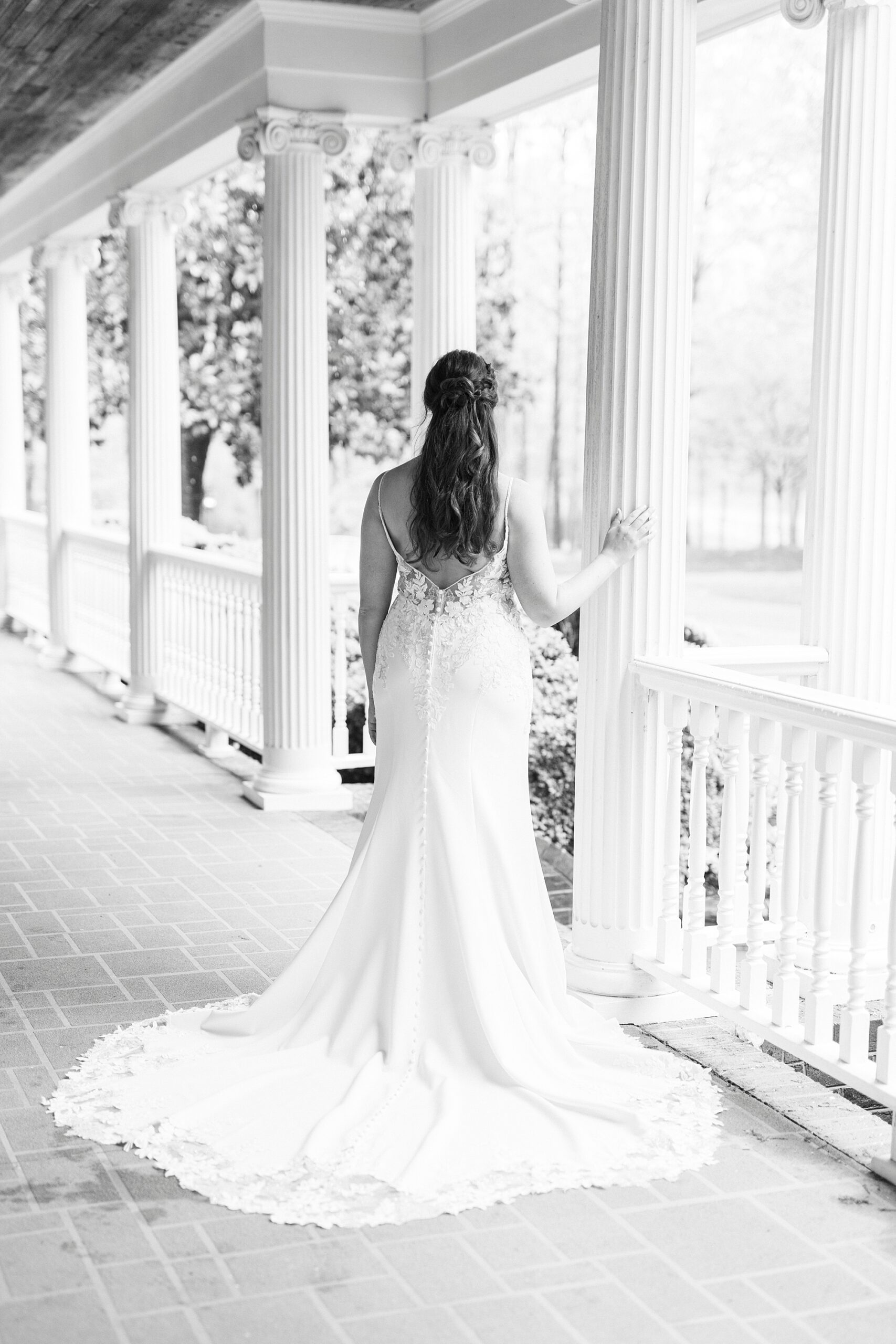 black and white portrait of bride walking by railing at The Saratoga Springs
