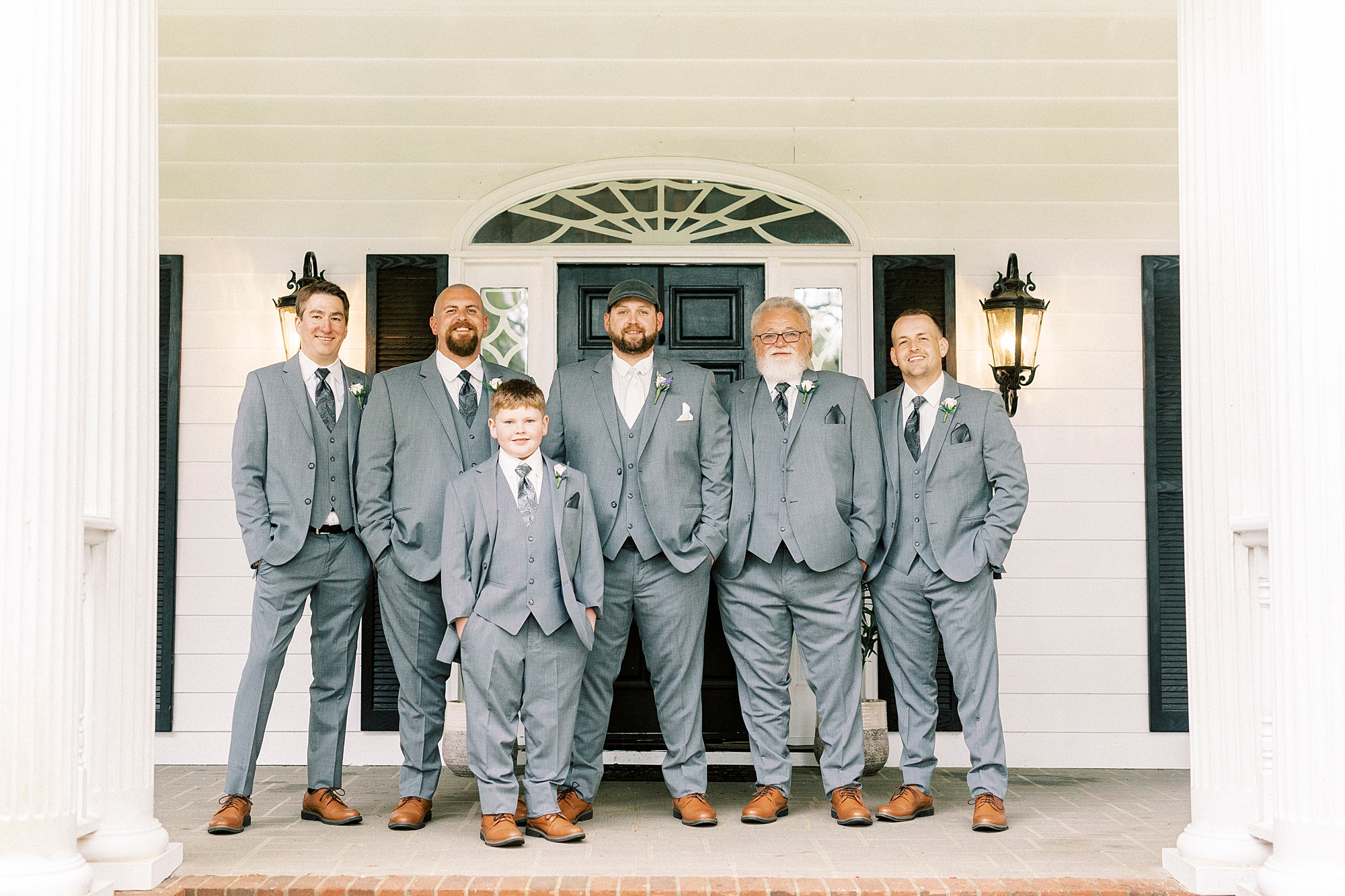 groom and groomsmen stand on front porch at The Saratoga Springs