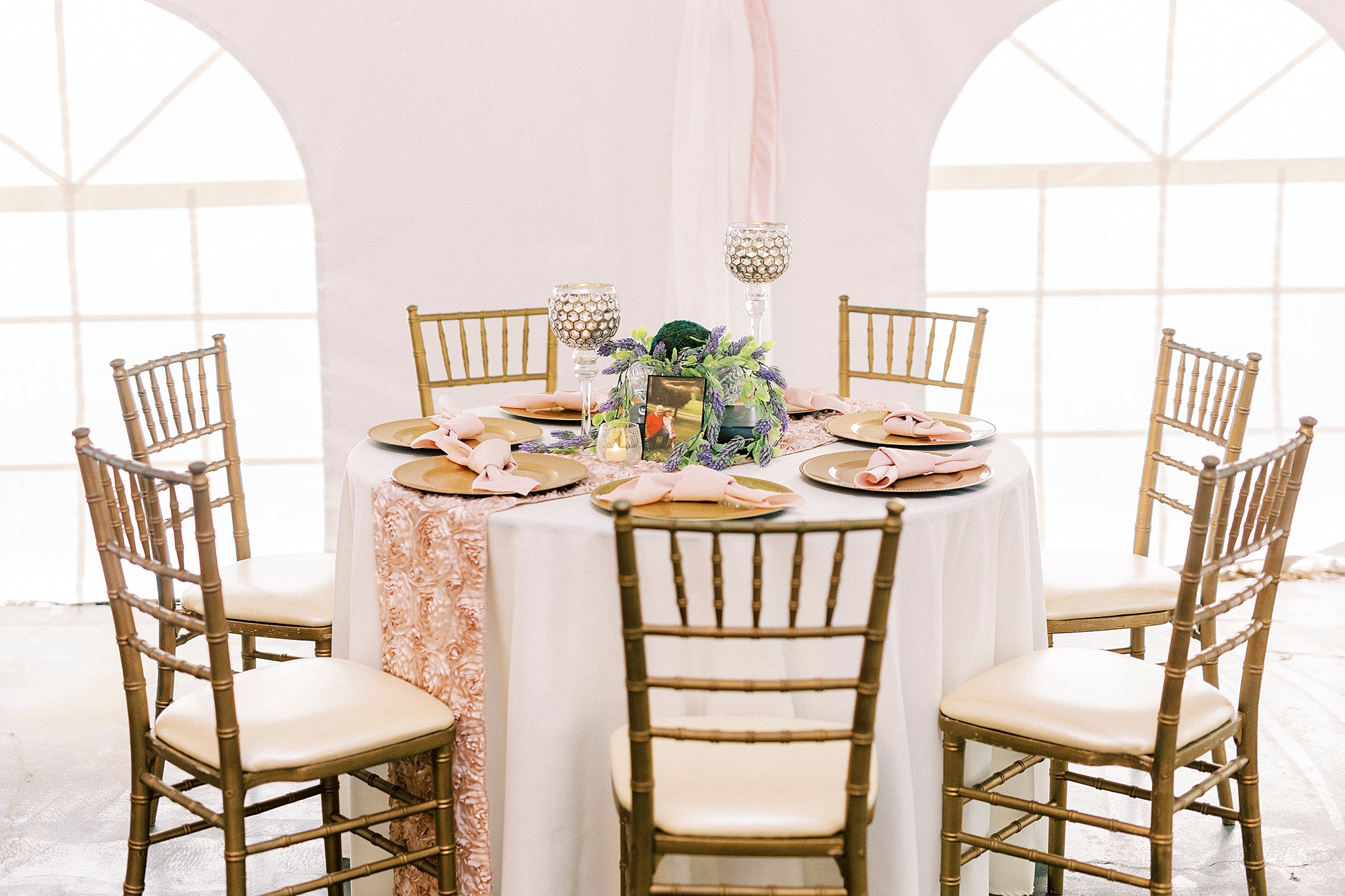 wedding reception under tent with greenery and bright floral centerpieces  