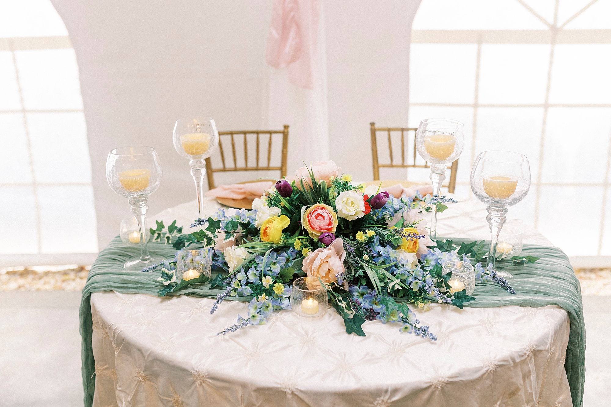 sweetheart table with floral display on green runner at The Saratoga Springs