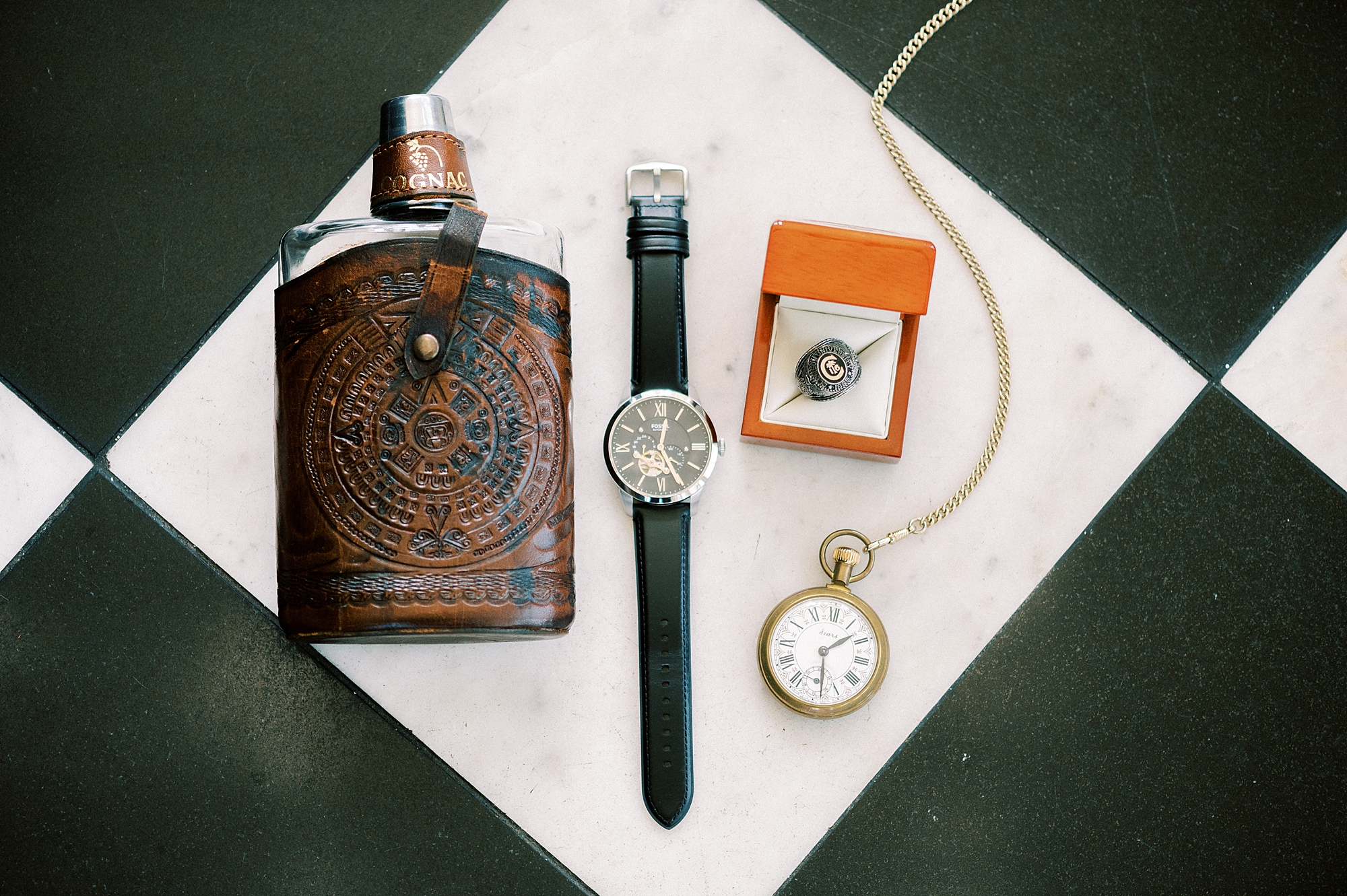 groom's watch and flask on black and white floor