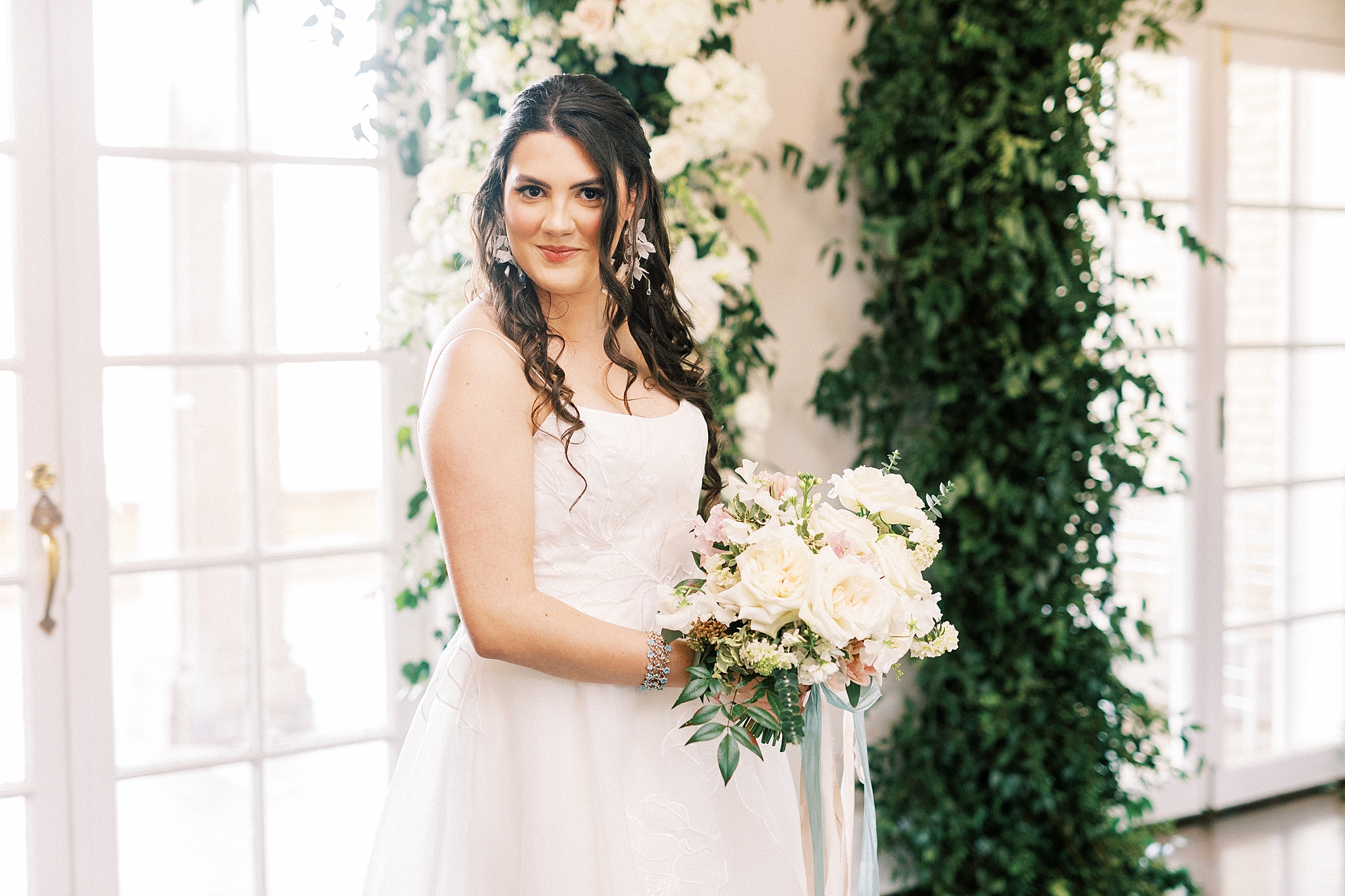 bride smiles holding bouquet of ivory roses during spring Separk Mansion wedding