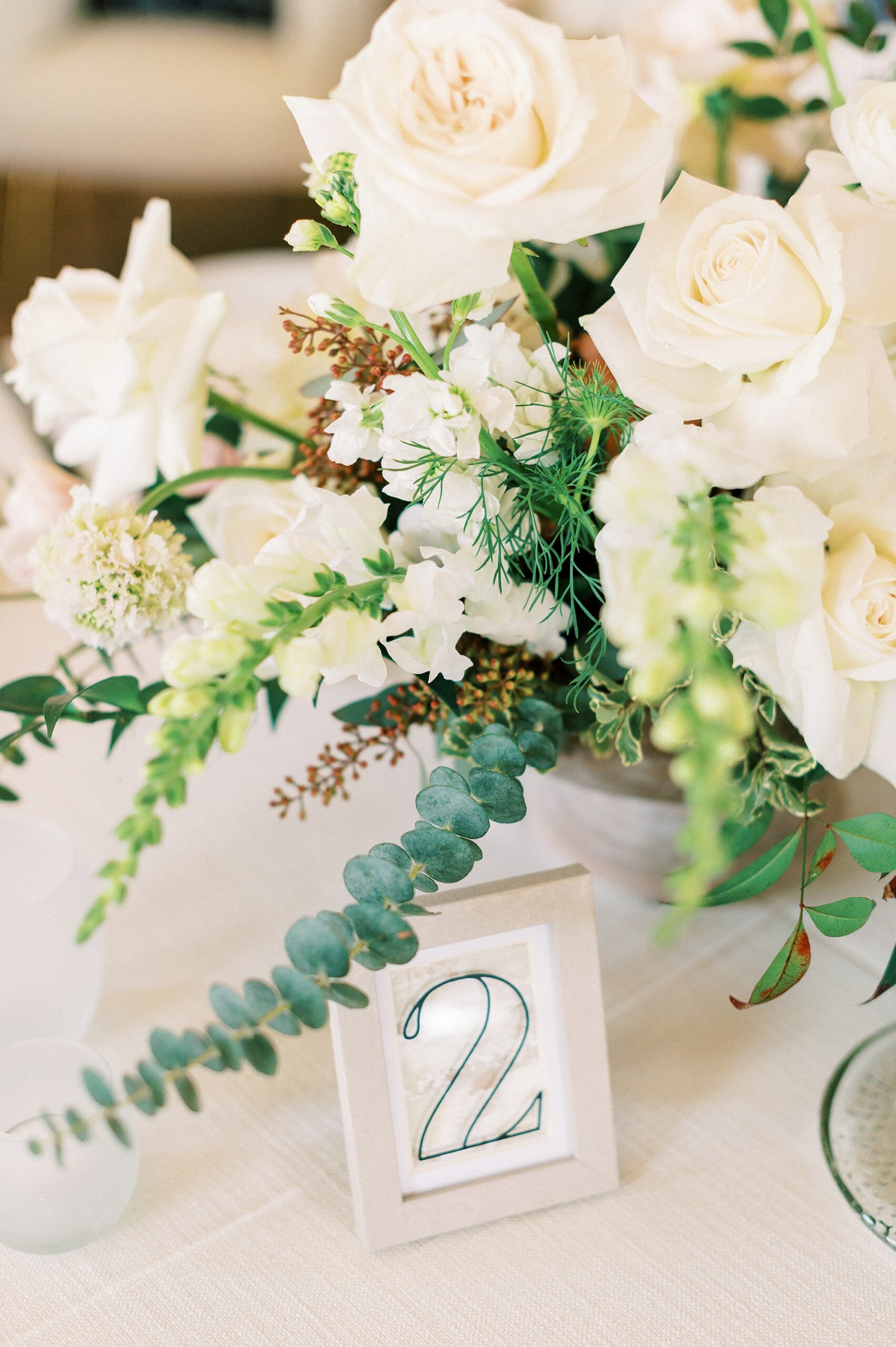 ivory rose centerpiece with table number for spring wedding reception 