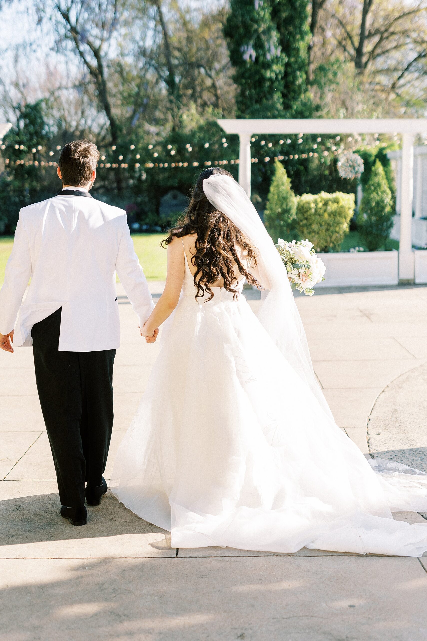 newlyweds hold hands walking towards garden at Separk Mansion