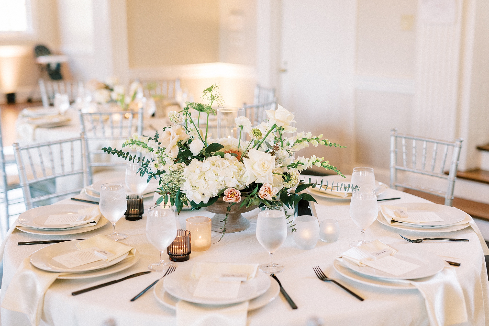 wedding reception table with ivory rose centerpiece and gold plates 