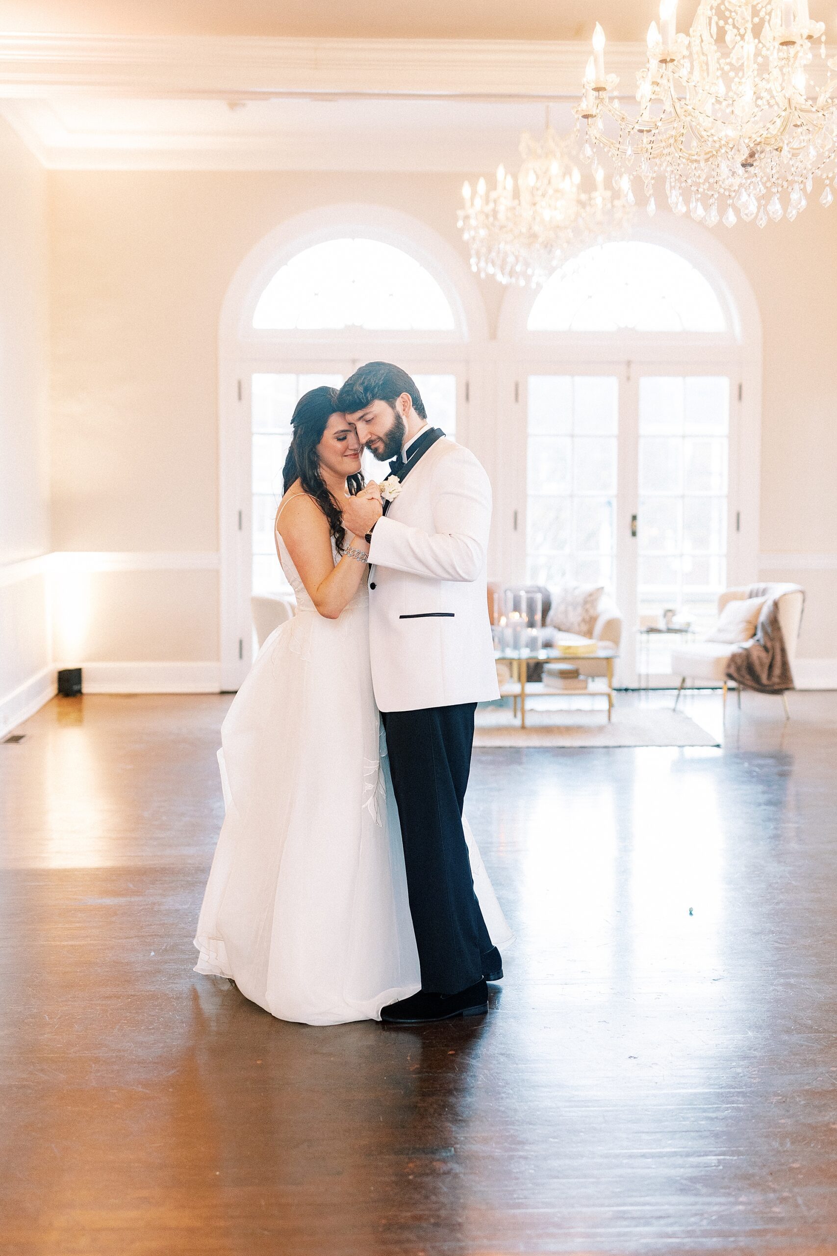 newlyweds hug close on dance floor during wedding reception 