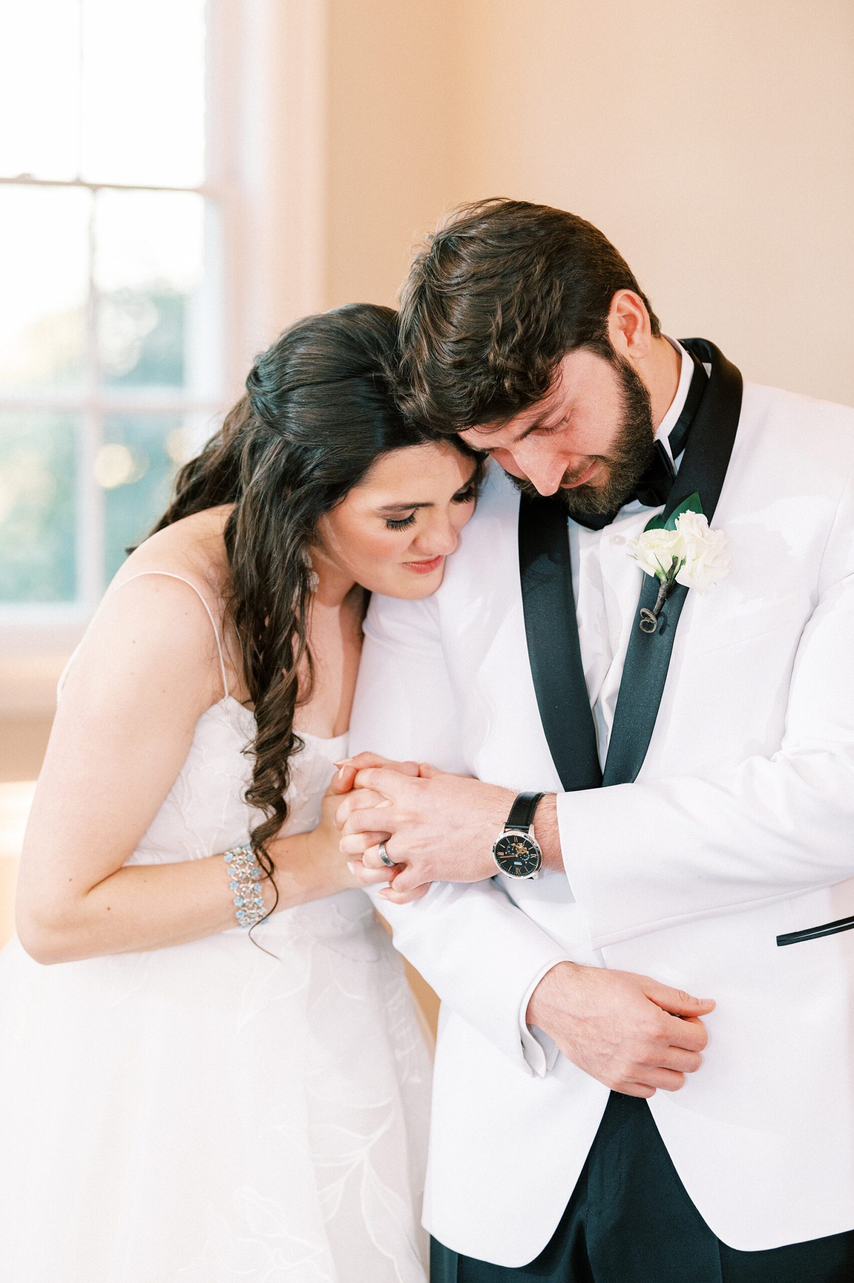 bride and groom hug holding hands during NC wedding reception 