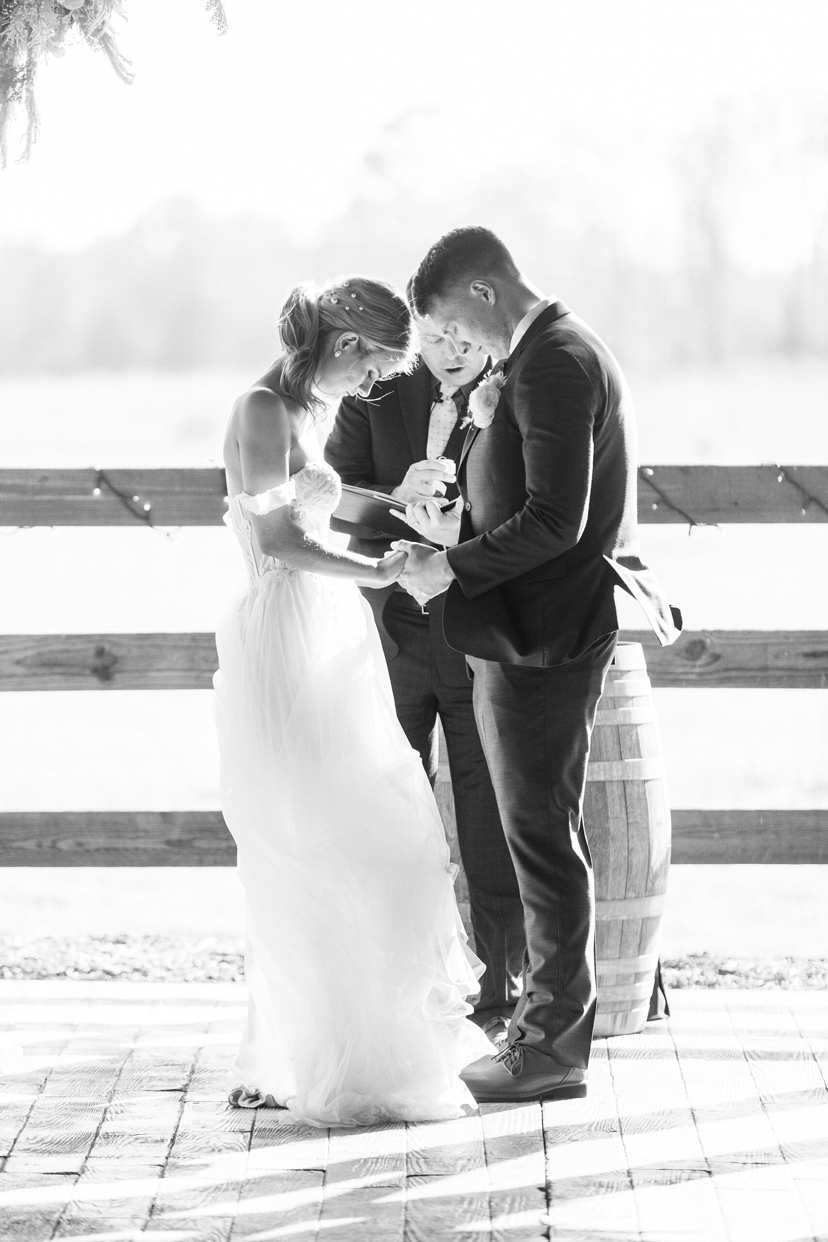 bride and groom pray during wedding ceremony at the Farmstead