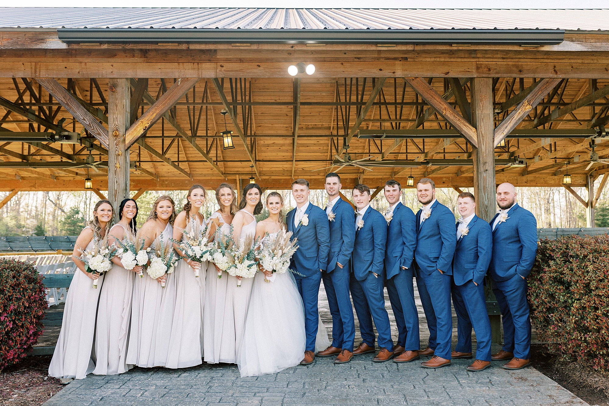 bride and groom stand with bridesmaids and groomsmen at the Farmstead