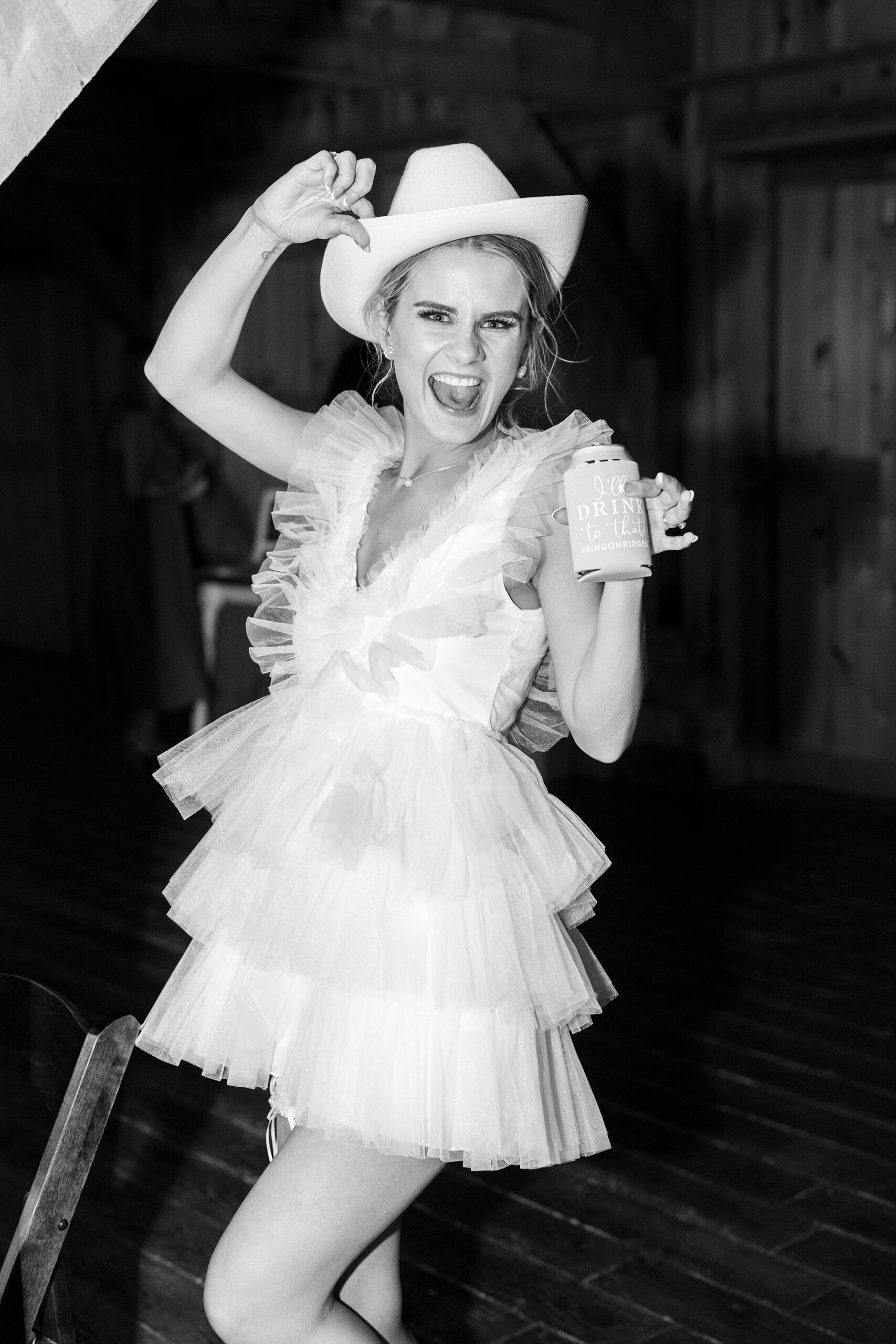 bride dances in reception dress with fringe and cowboy hat 