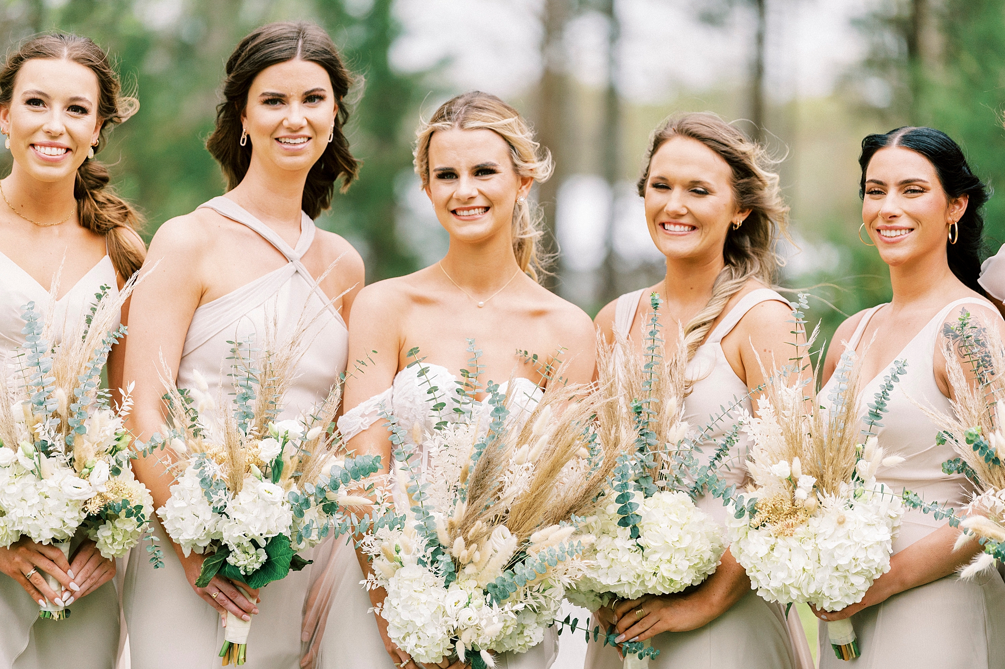 bride stands with bridesmaids holding country chic bouquets 