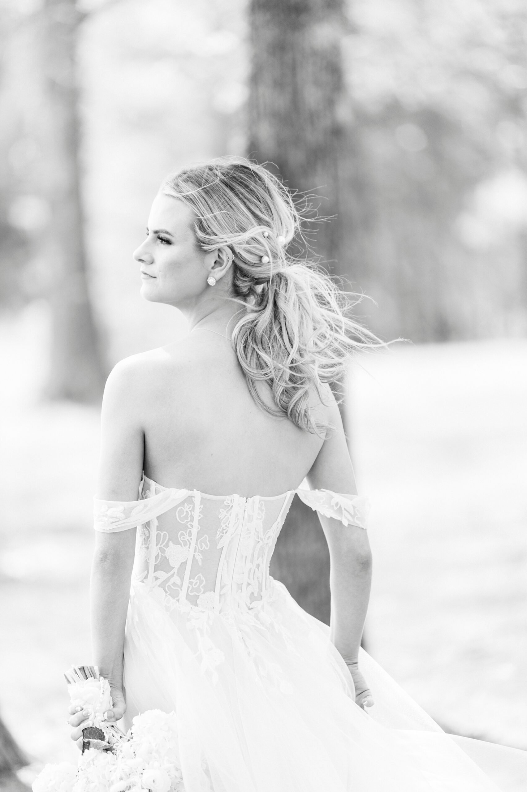 black and white portrait of bride looking over shoulder in wedding dress with corset 