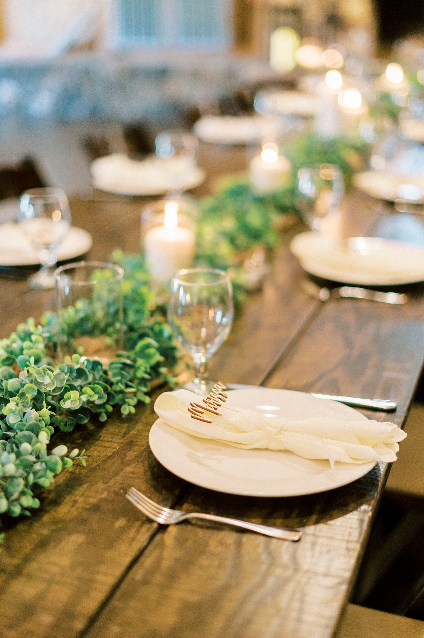 wedding reception at The Farmstead with greenery and place settings with custom names 