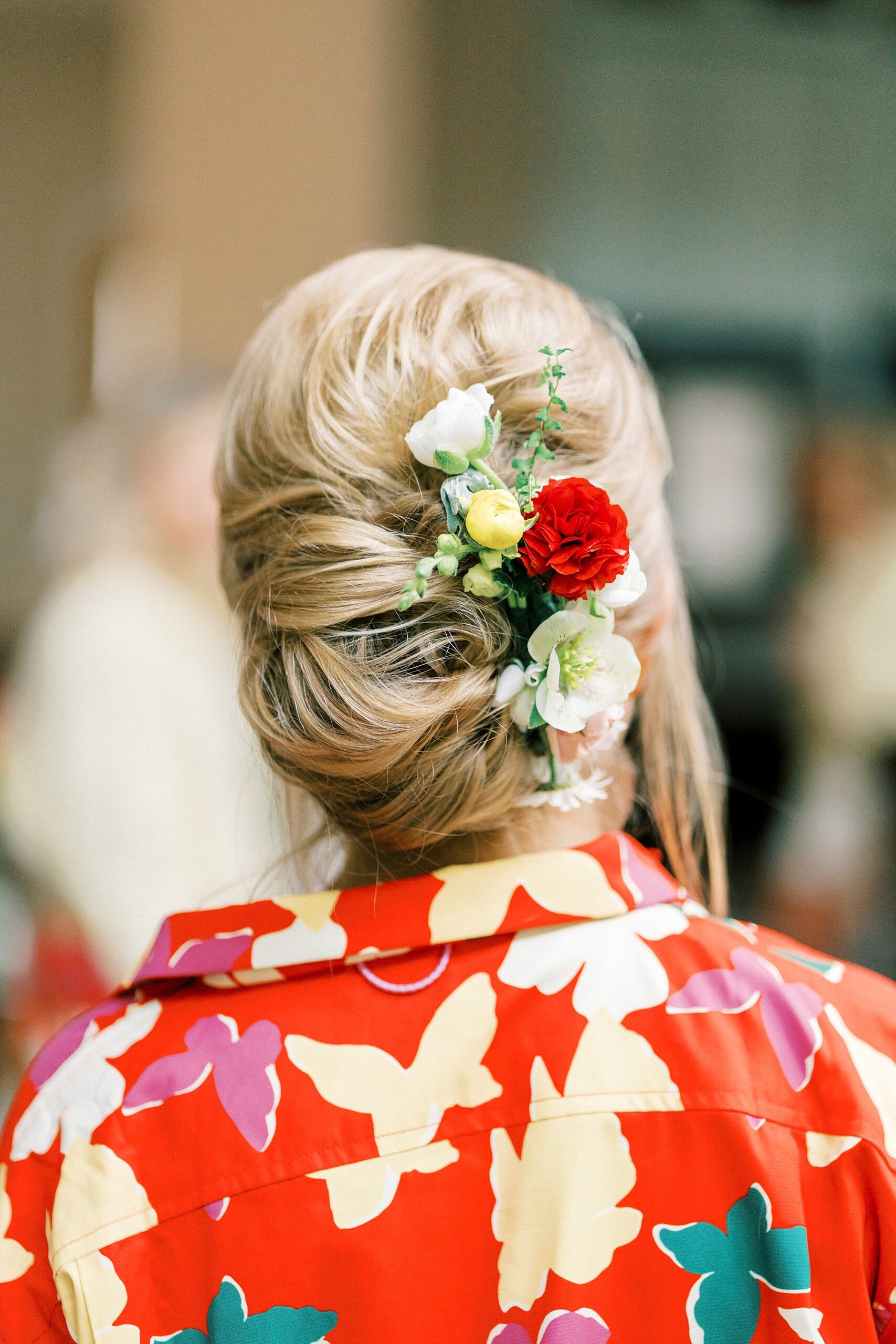 bride's updo with red and white flowers 