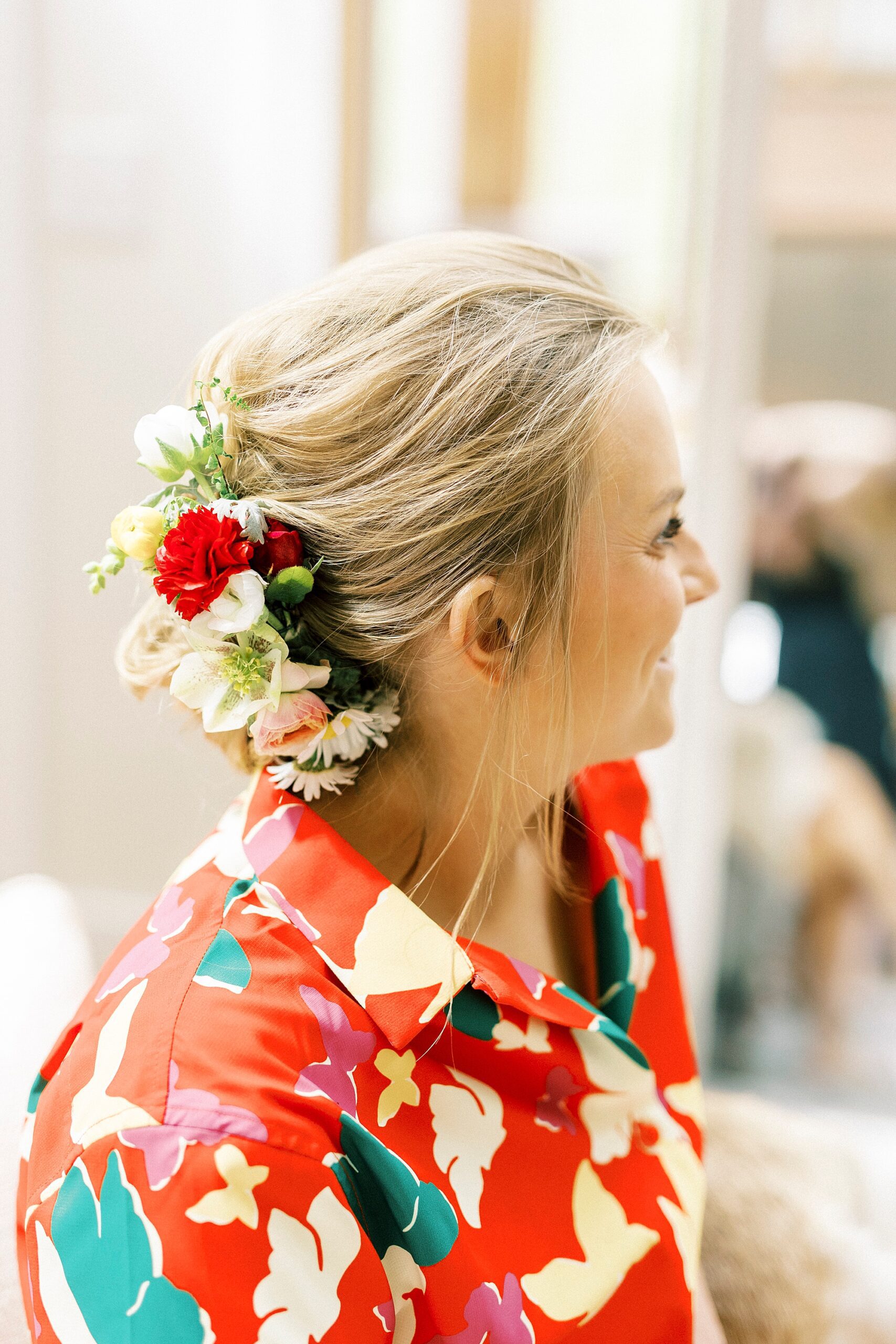 bride shows off updo with red and white flowers 