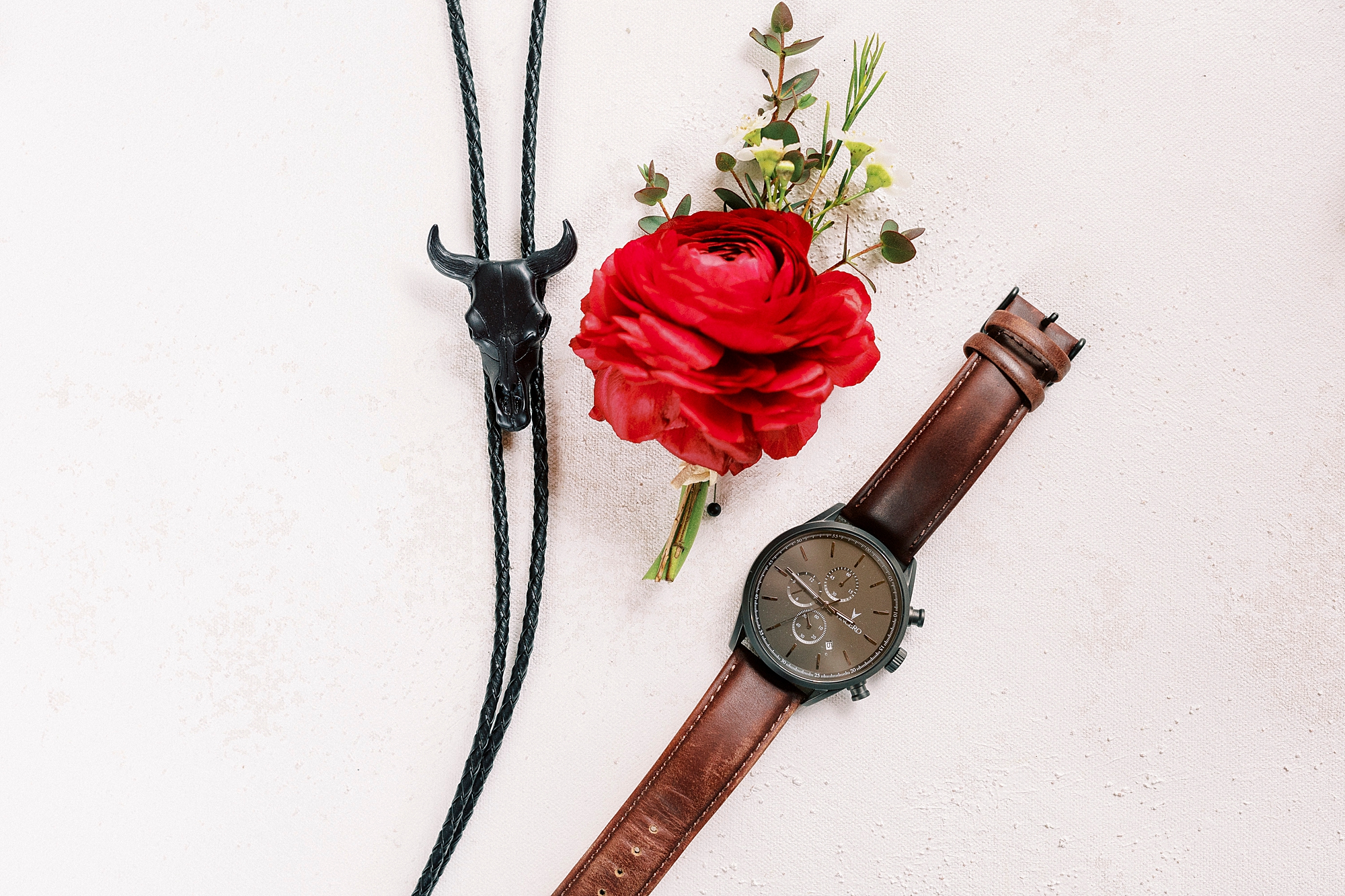 groom's bolo tie, red boutonnière and watch