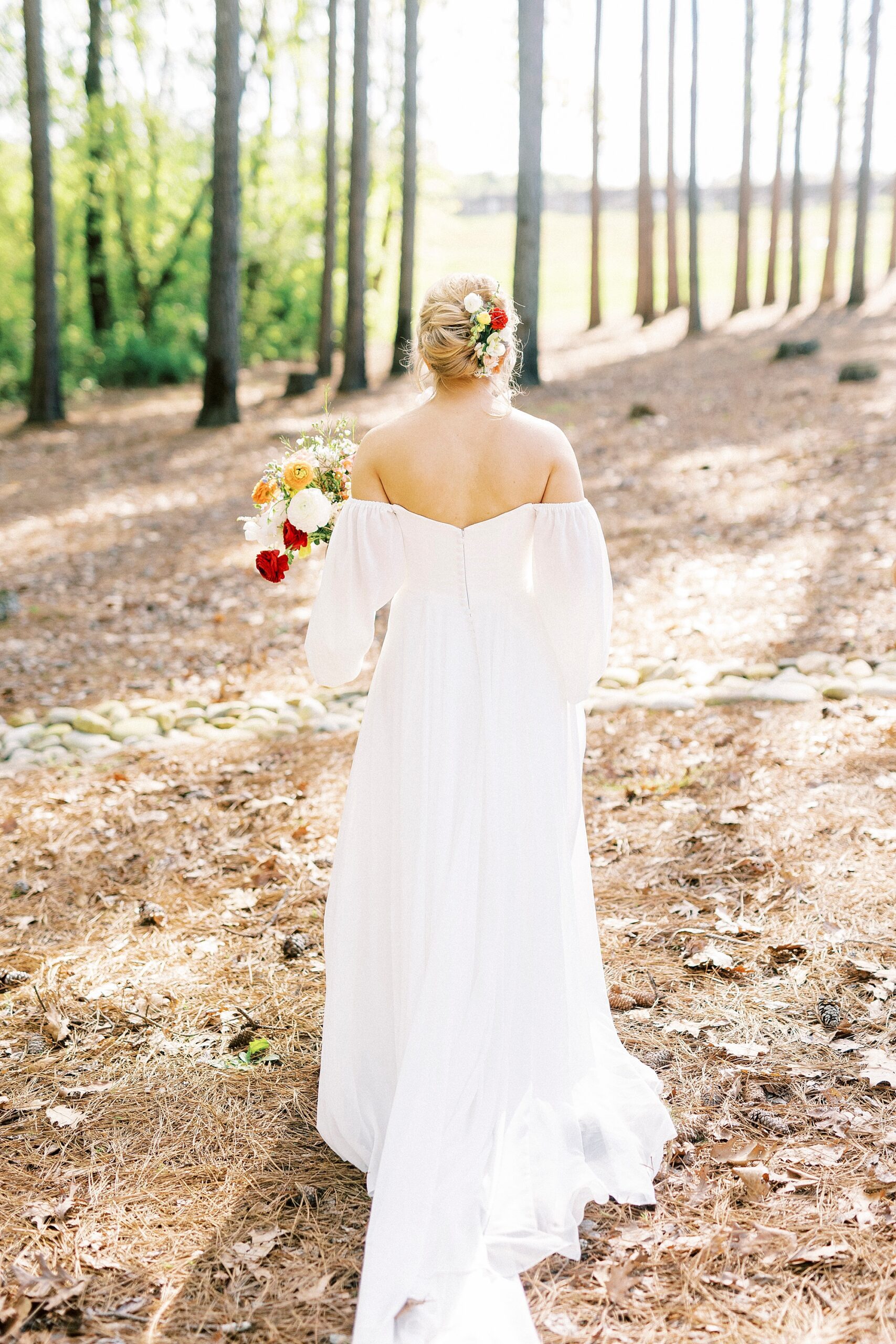 boho bride walks in yard in off-the-shoulder gown