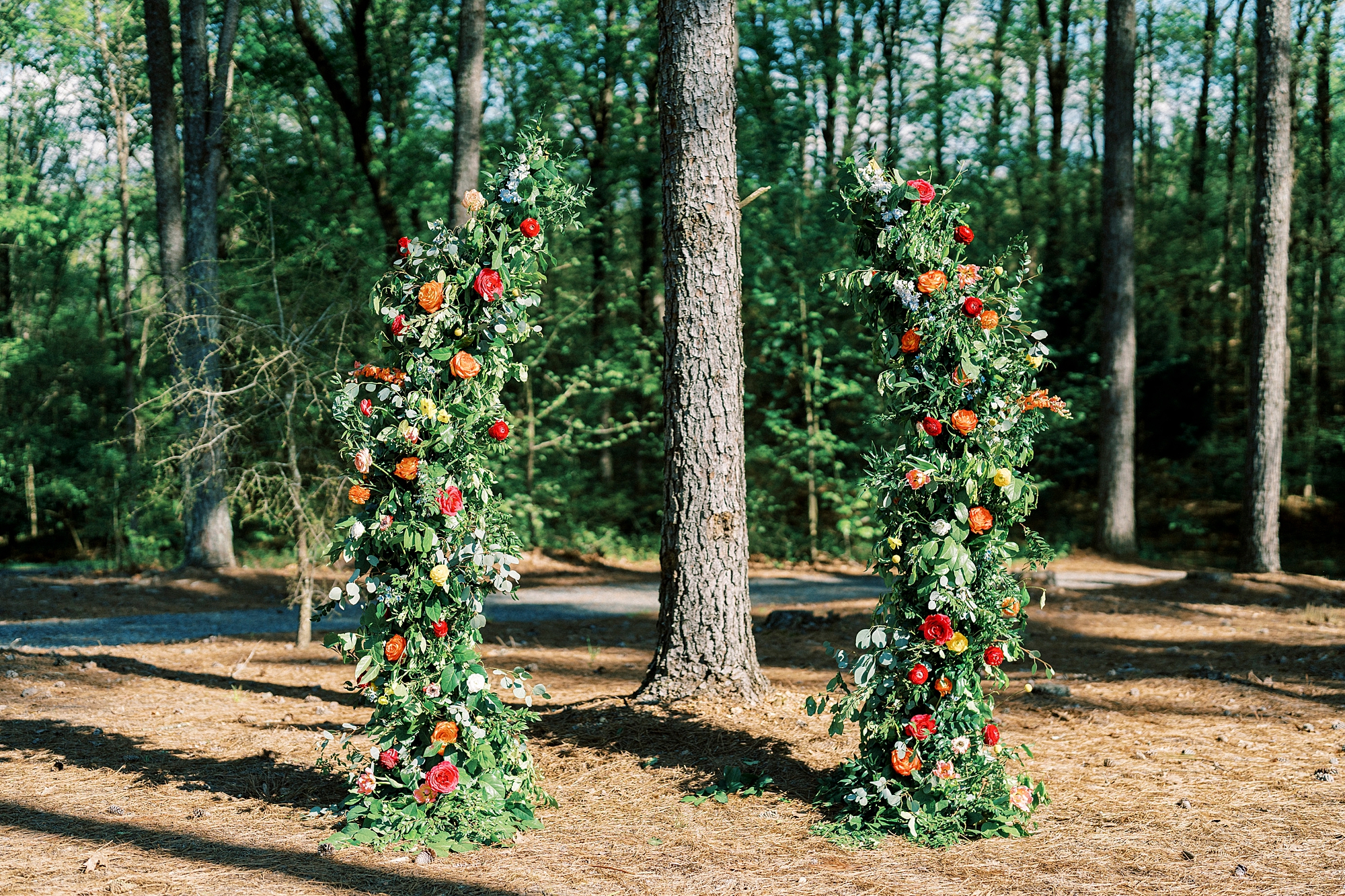 tall floral arrangements for ceremony with red and yellow flowers 