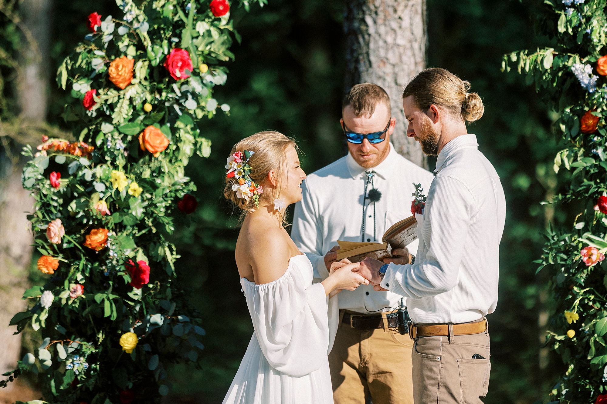 bride smiles at groom exchanging vows during wedding ceremony on lawn of Richfield NC home