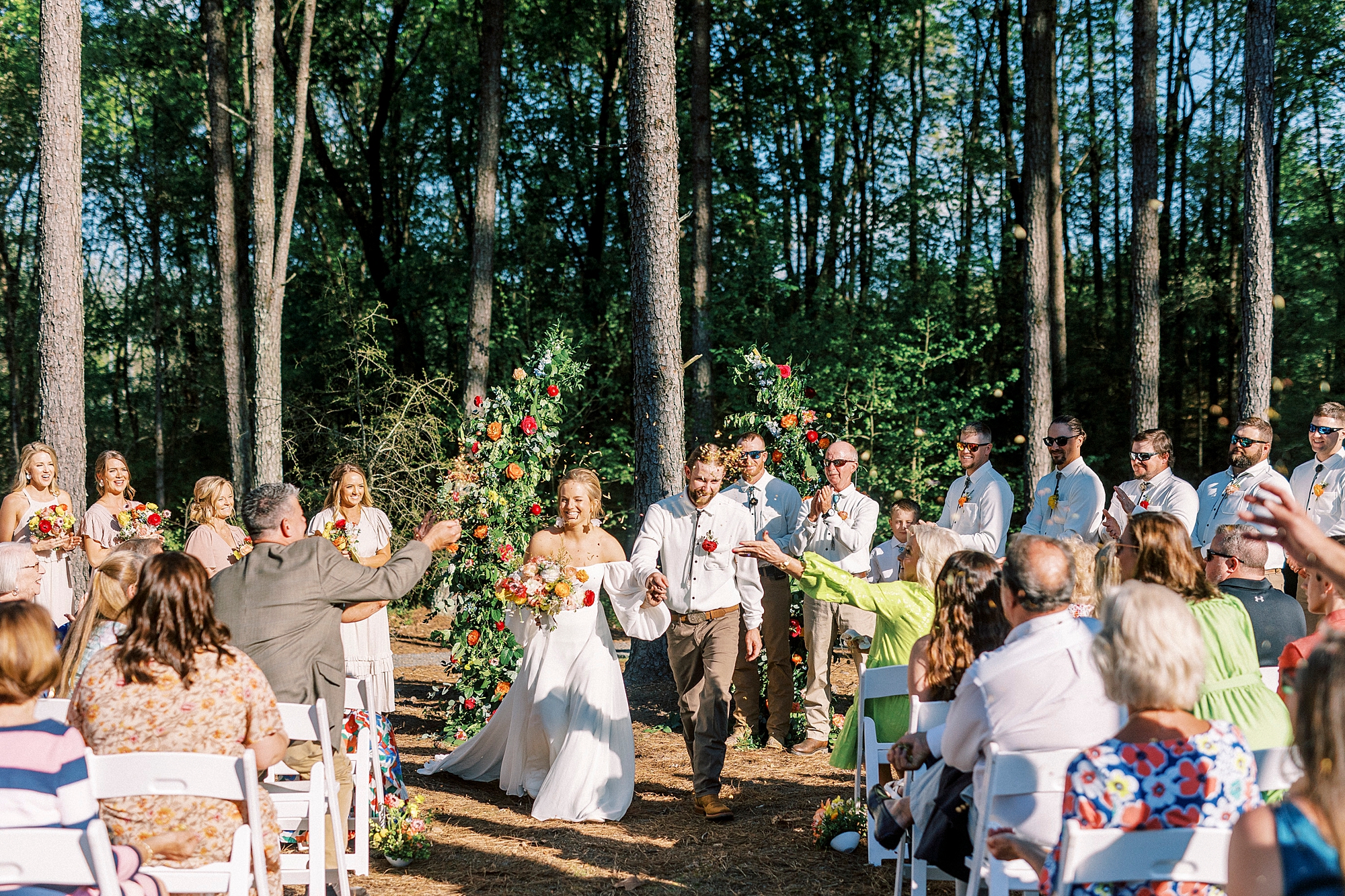 bride and groom walk up aisle after wedding ceremony on lawn of Richfield NC home