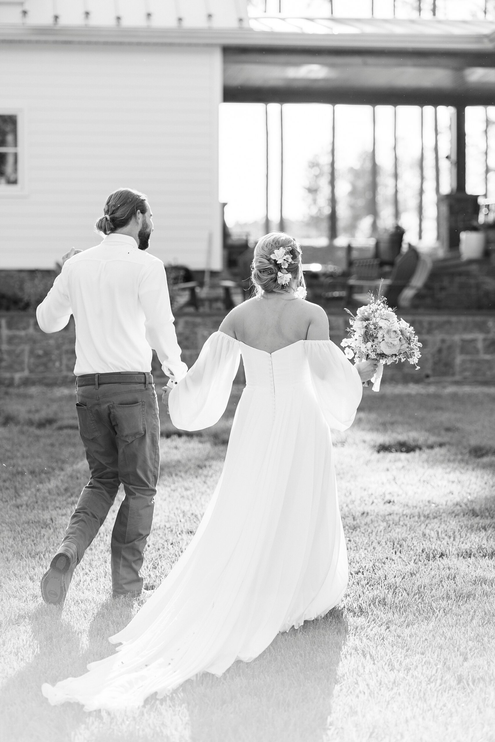 bride and groom hold hands walking away from wedding ceremony on lawn of Richfield NC home