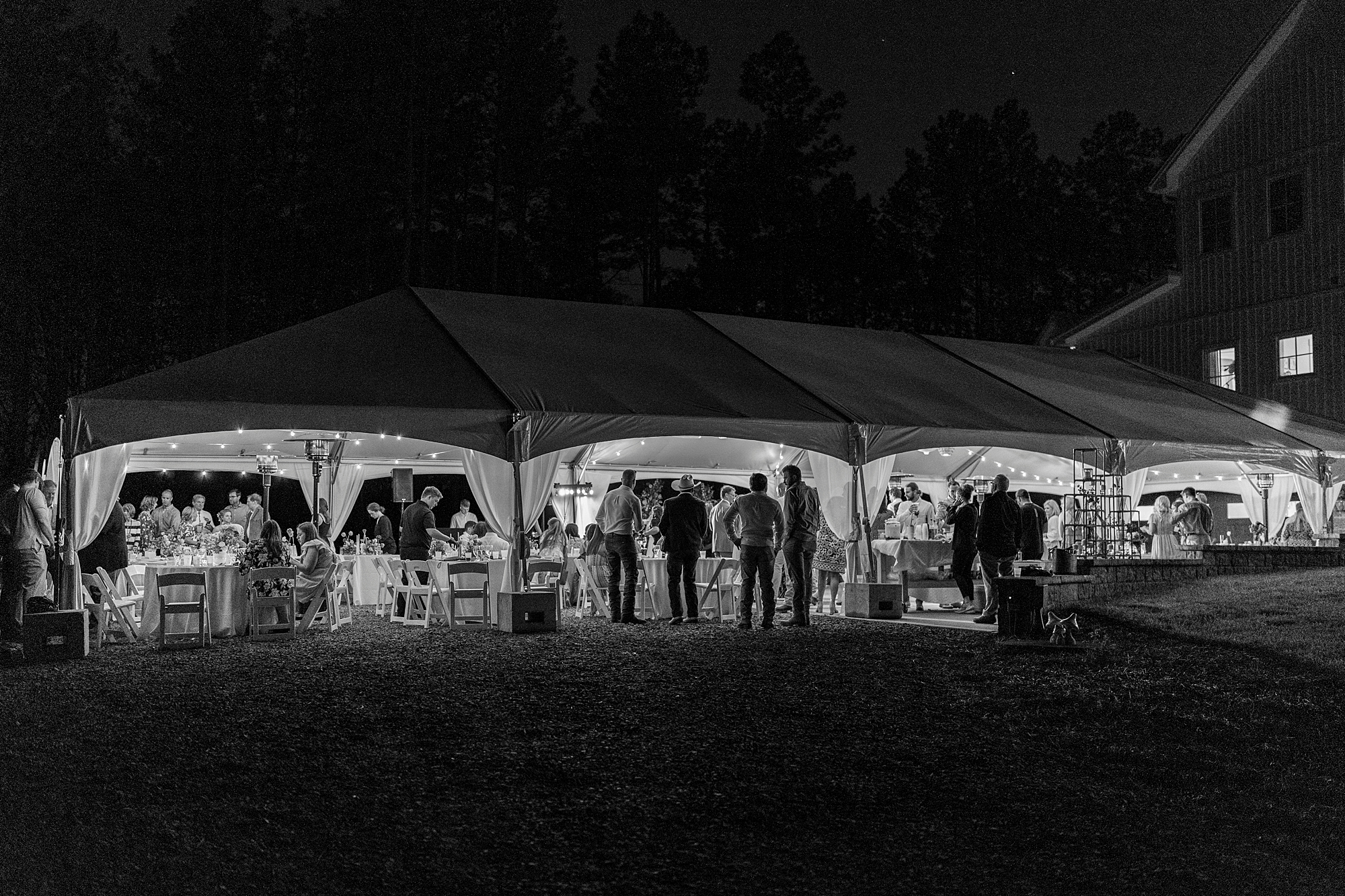 white tent lit up for wedding reception on lawn in Richfield NC