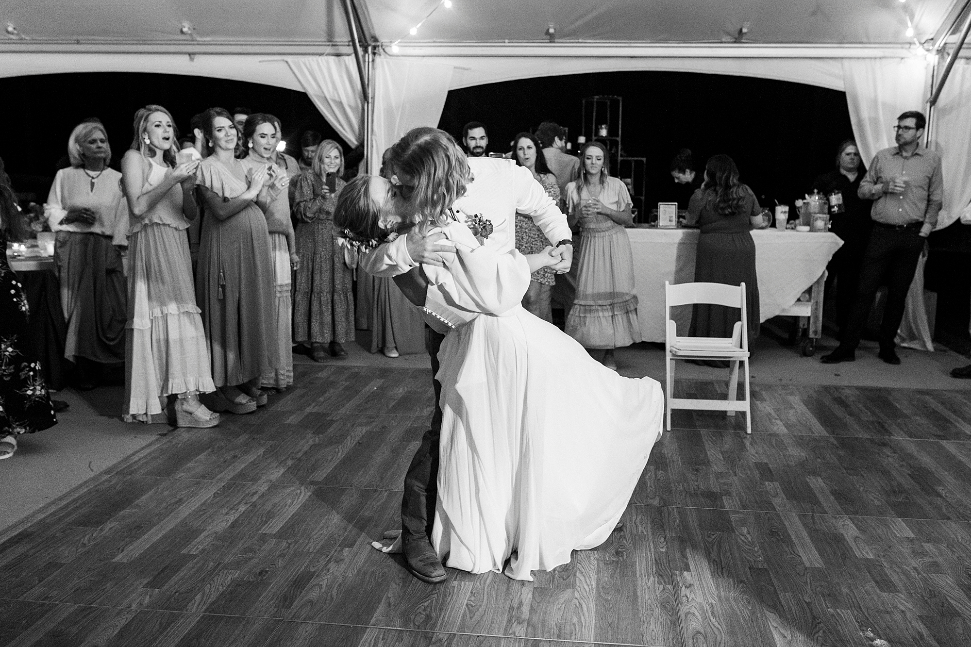 groom dips bride kissing her on dance floor at wedding reception on lawn in Richfield NC
