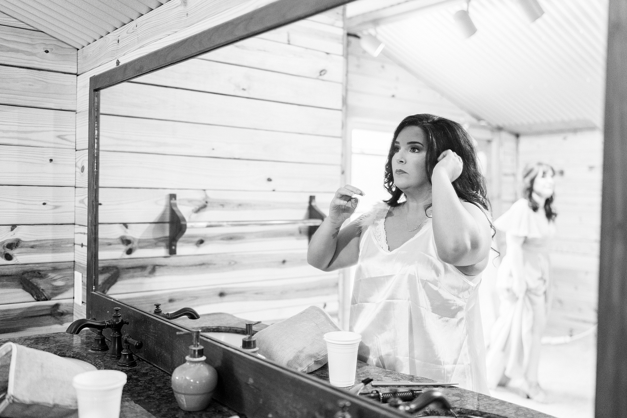 bride applies makeup in mirror at Danner Farms
