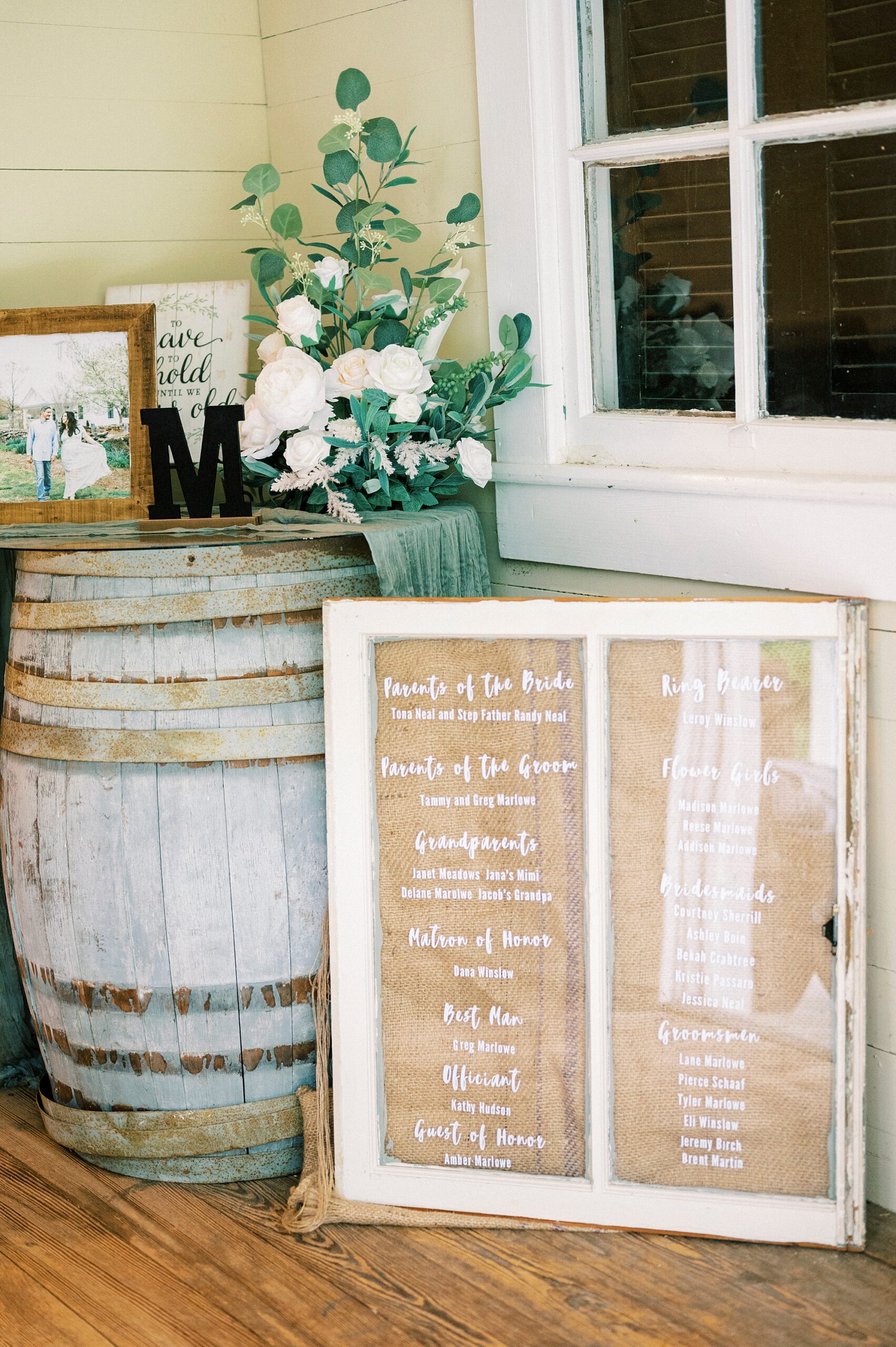 seating chart on glass window for reception in barn at Danner Farms
