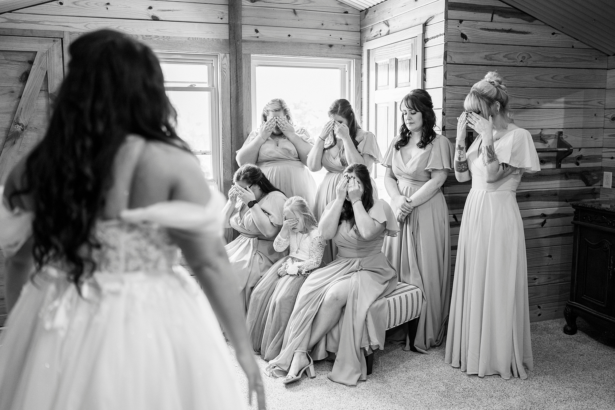 bridesmaids cover eyes for first look with bride in suite at Danner Farms