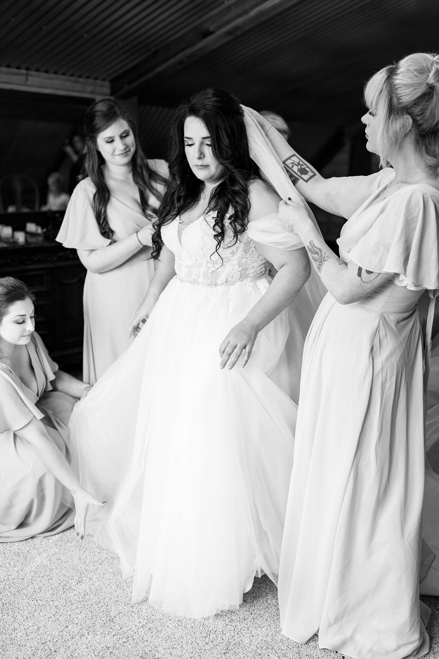 bridesmaids help bride with veil in hair before NC wedding