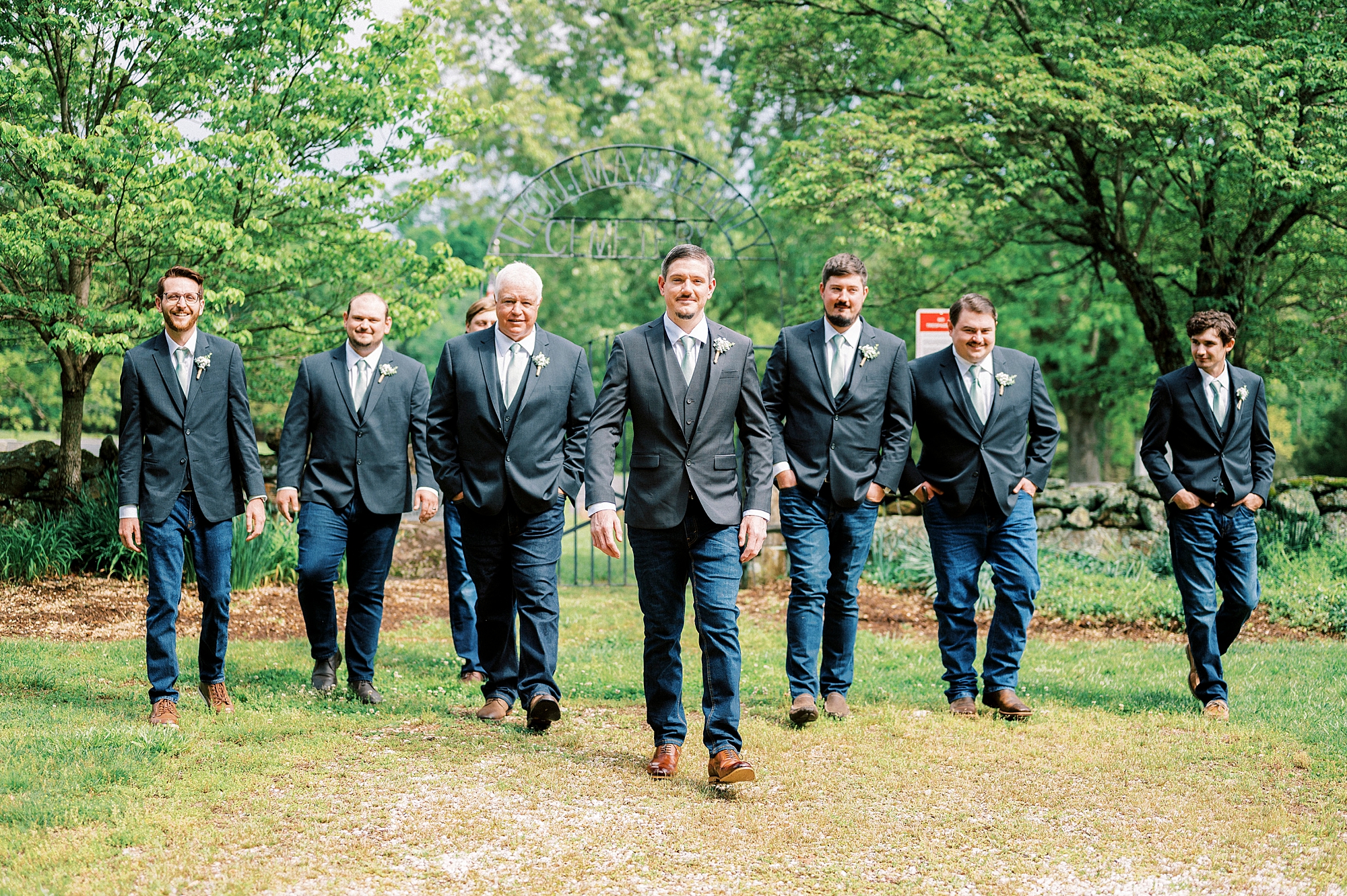 groom walks with groomsmen in navy suits at Danner Farms