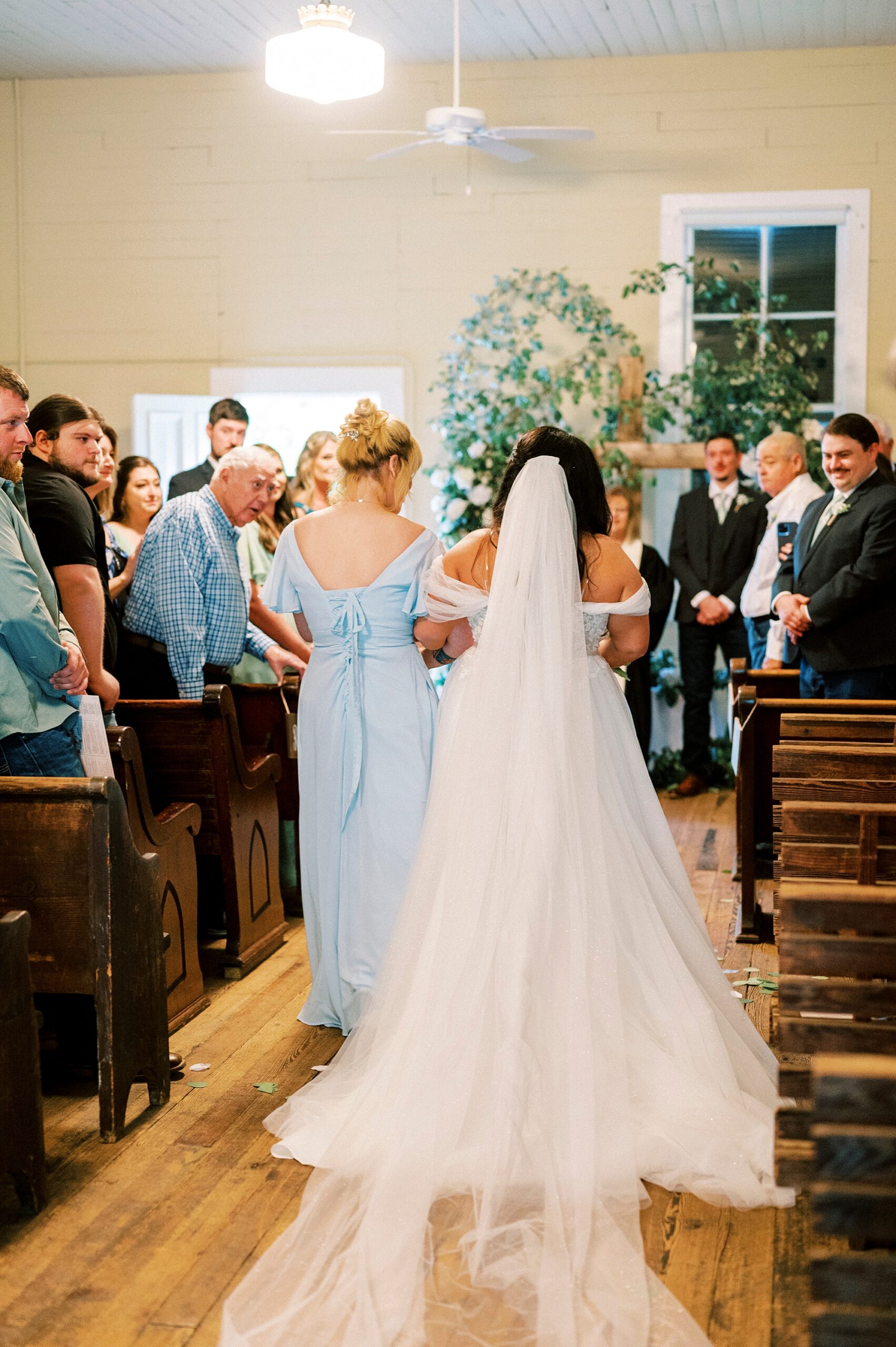 bride and mother walk down aisle at Troutman Historical Cemetery chapel
