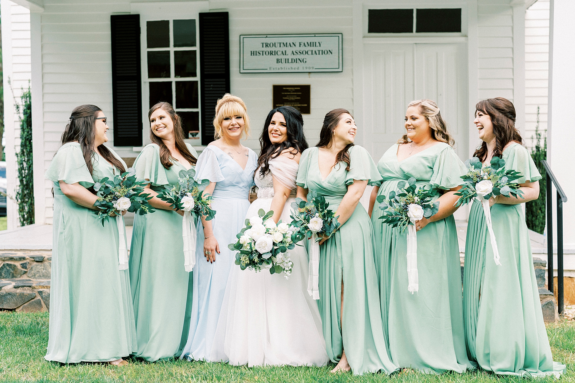 bride smiles with bridesmaids in mint green gowns at Danner Farms
