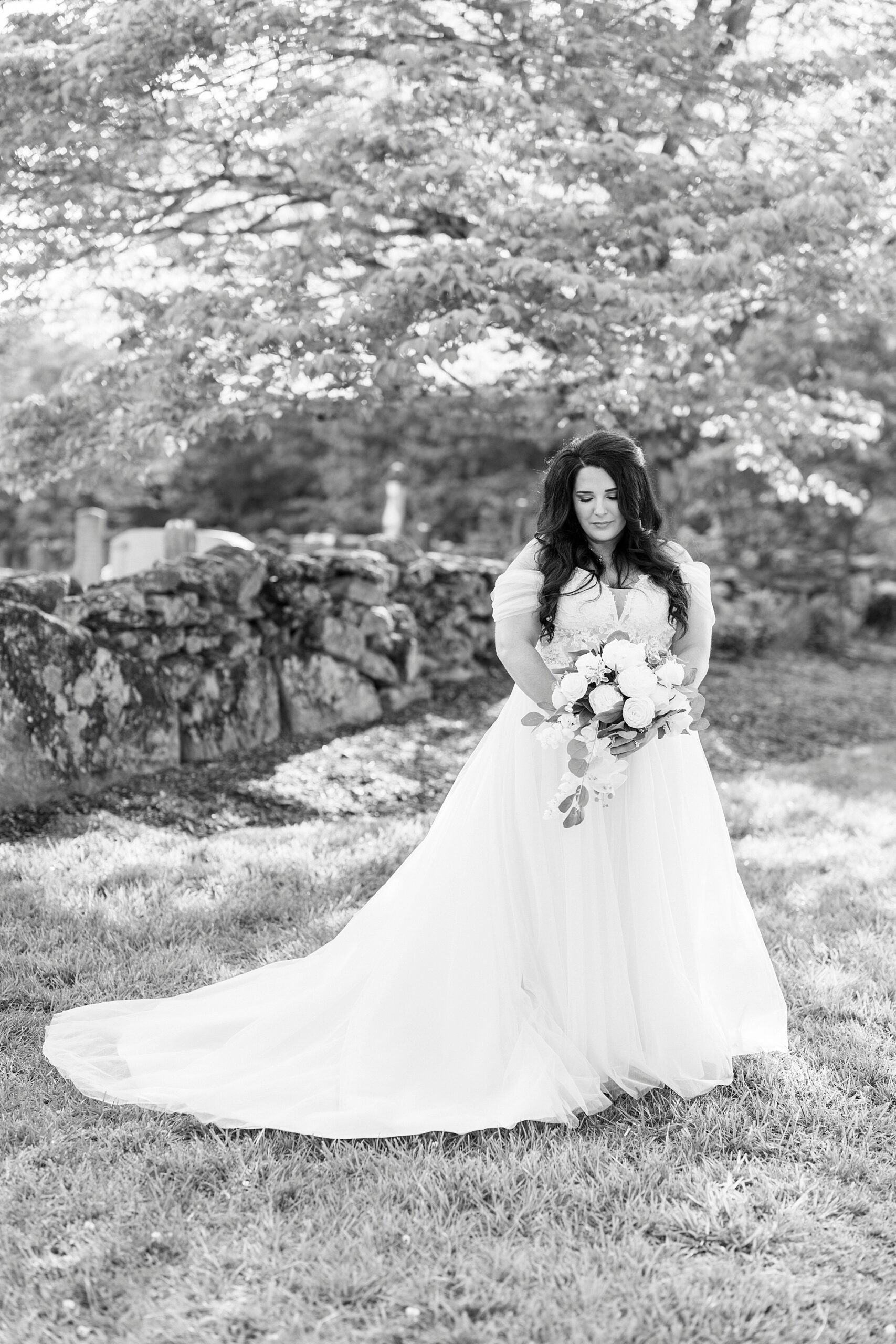 bride stands smiling holding wedding bouquet in front of her at Danner Farms