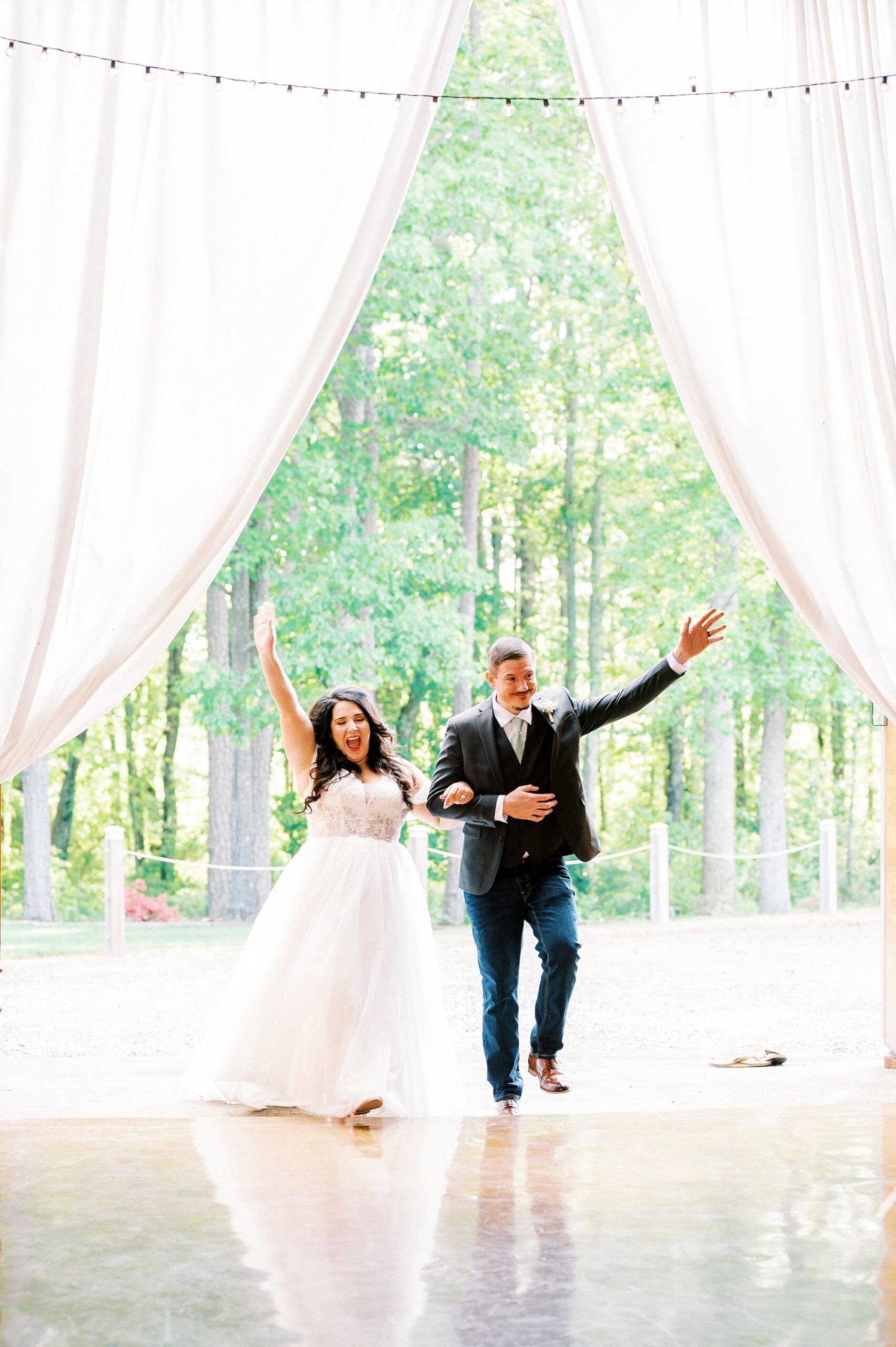 newlyweds cheer walking into wedding reception at Danner Farms