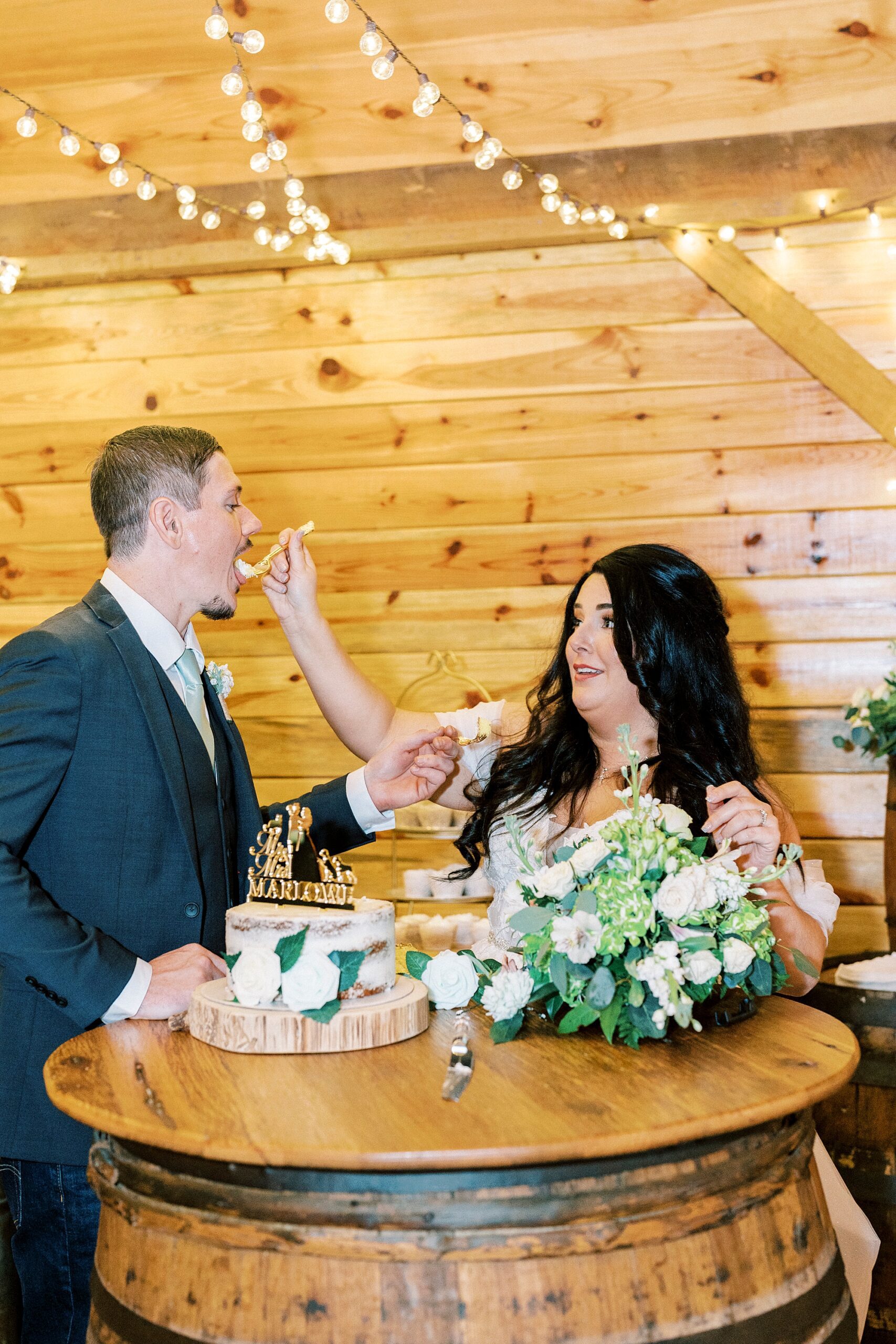 bride feeds groom cupcake during wedding reception at Danner Farms