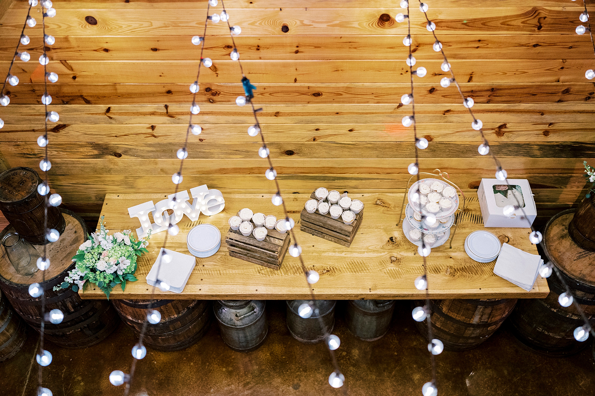 dessert display in barn with fairy lights