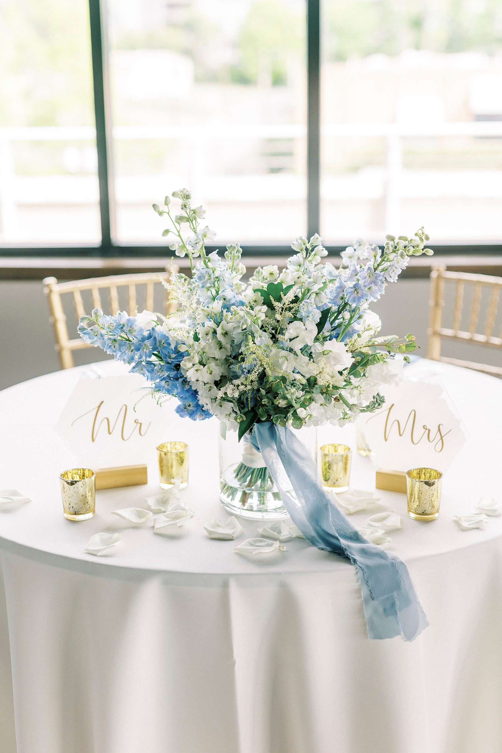 bride's blue and white floral bouquet sits in vase on sweetheart table at the Terrace at Cedar Hill