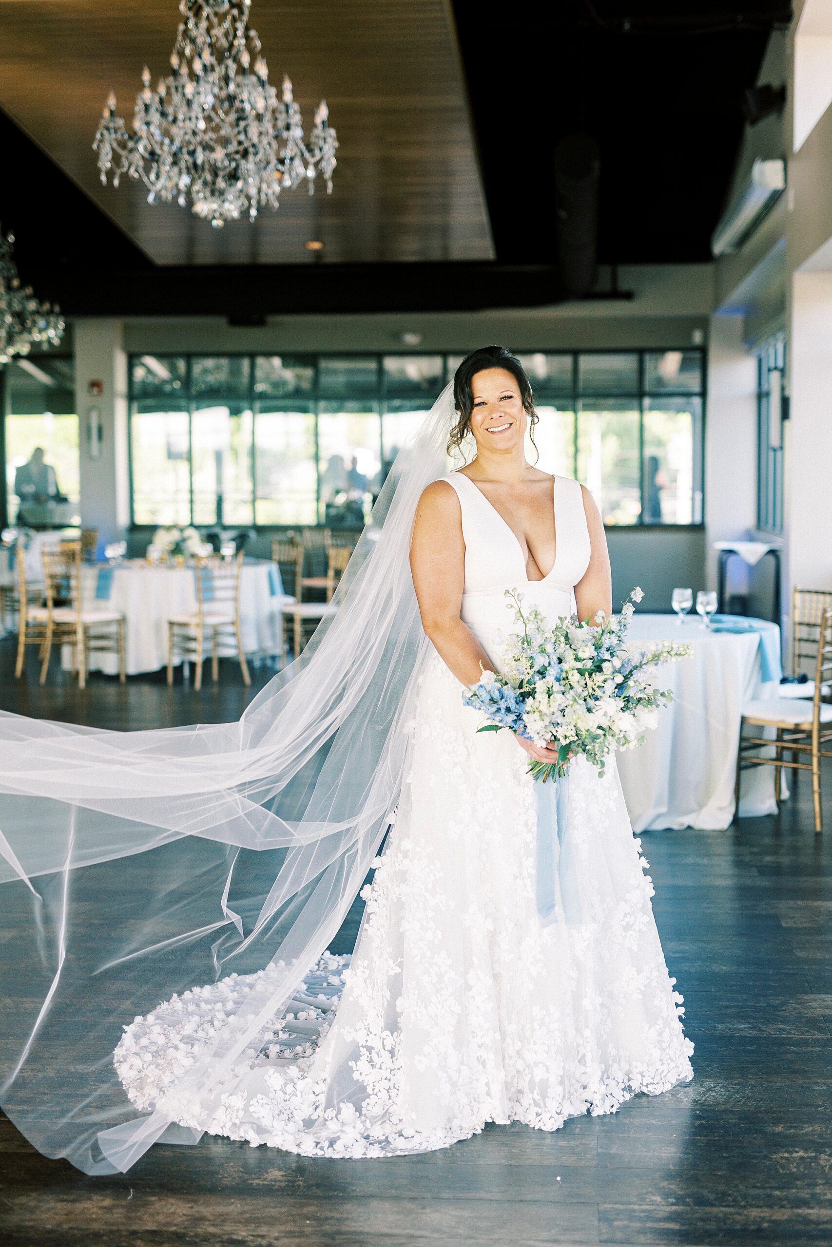 bride stands in reception space with veil floating at the Terrace at Cedar Hill